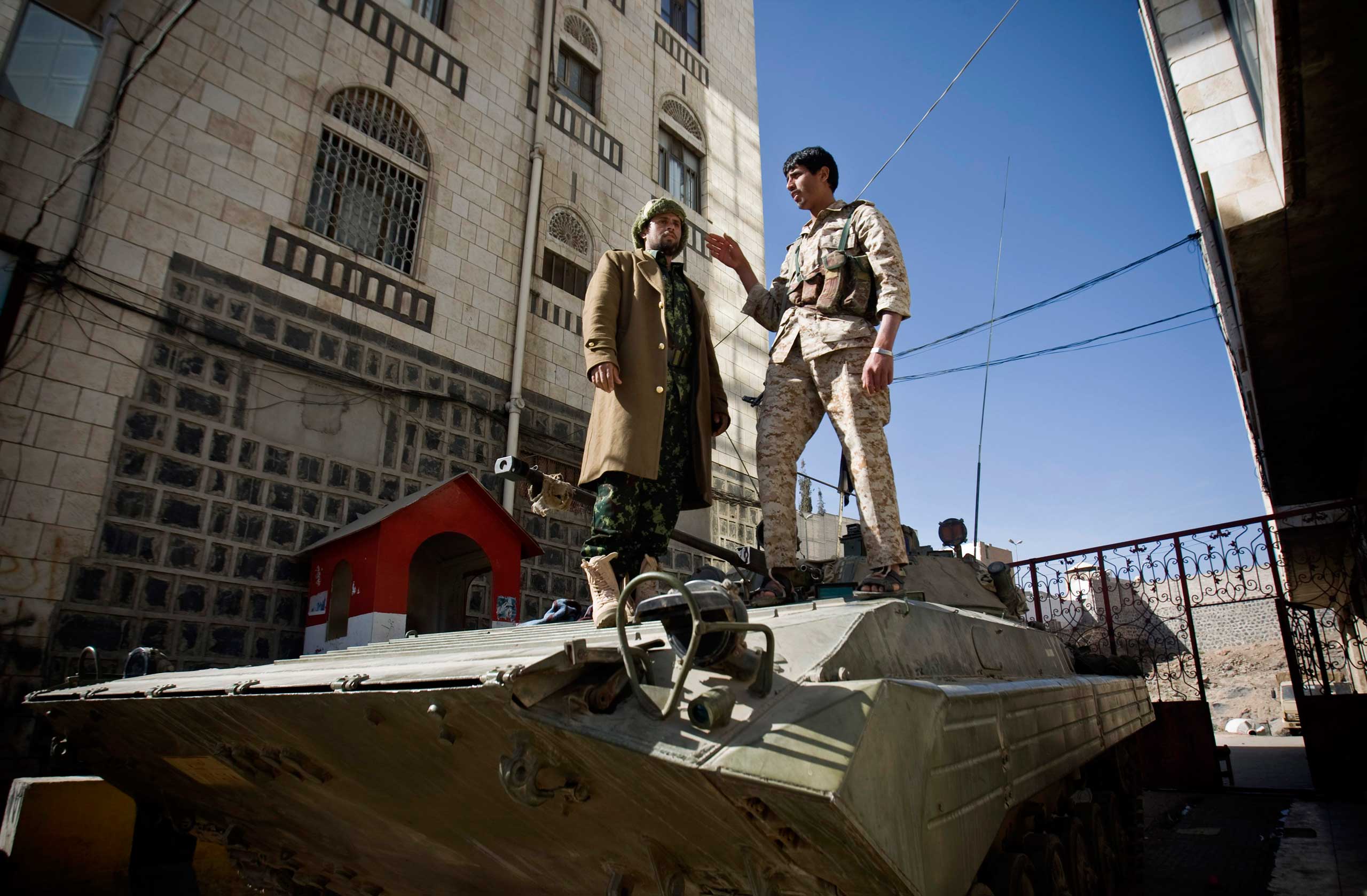 Houthi Shiite Yemeni wearing army uniforms stand atop an armored vehicle, which was seized from the army during recent clashes, outside the house of Yemen's President Abed Rabbo Mansour Hadi in Sanaa, Yemen, Jan. 22, 2015.