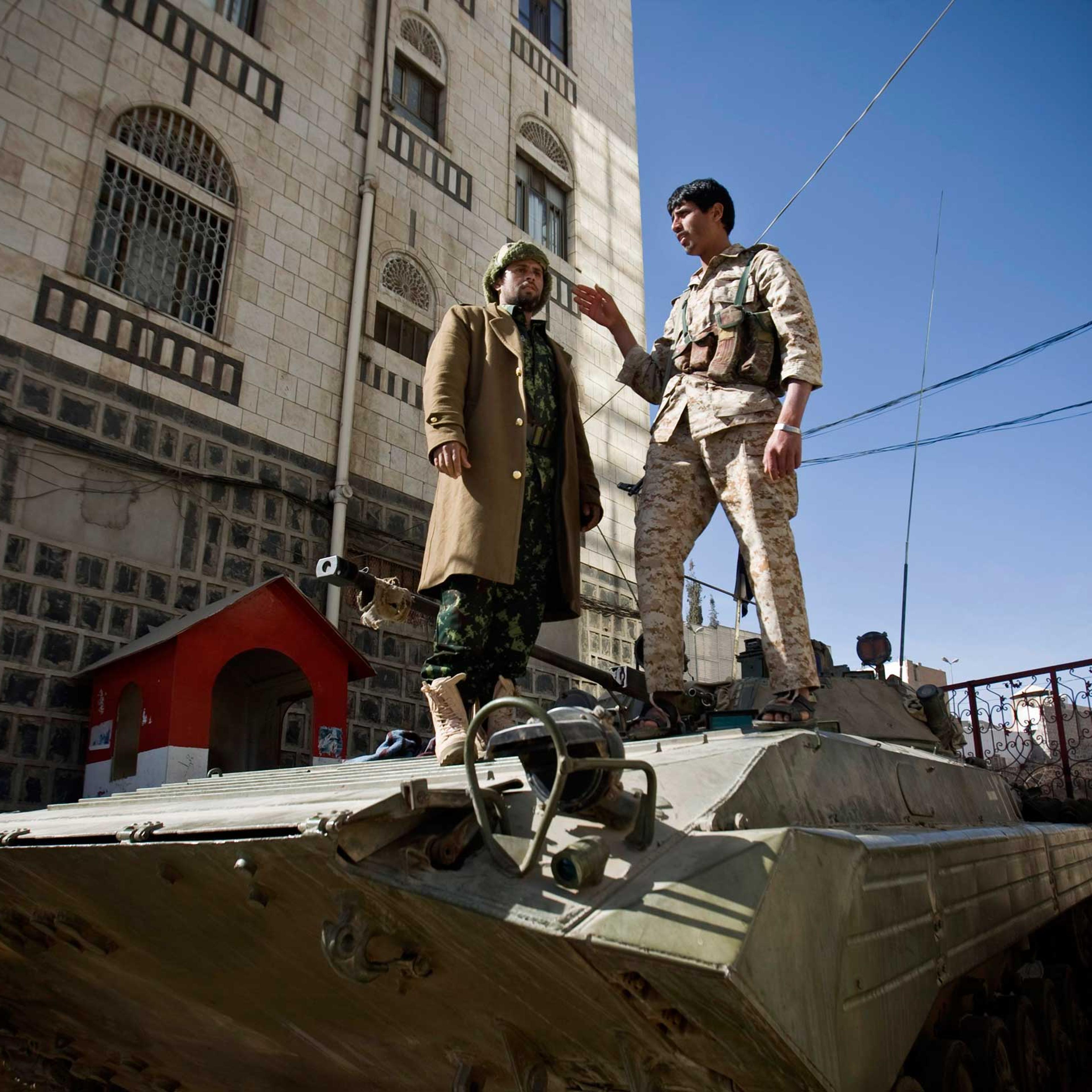 Houthi Shiite Yemeni wearing army uniforms stand atop an armored vehicle, which was seized from the army during recent clashes, outside the house of Yemen's President Abed Rabbo Mansour Hadi in Sanaa, Yemen, Jan. 22, 2015.
