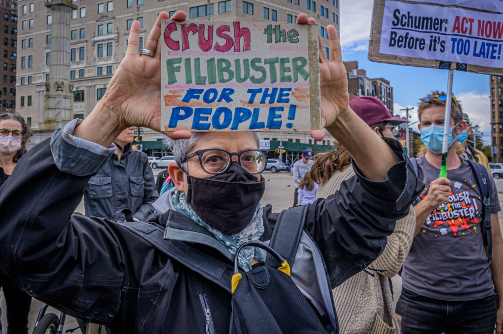 Participant seen holding a sign at the protest. Fair