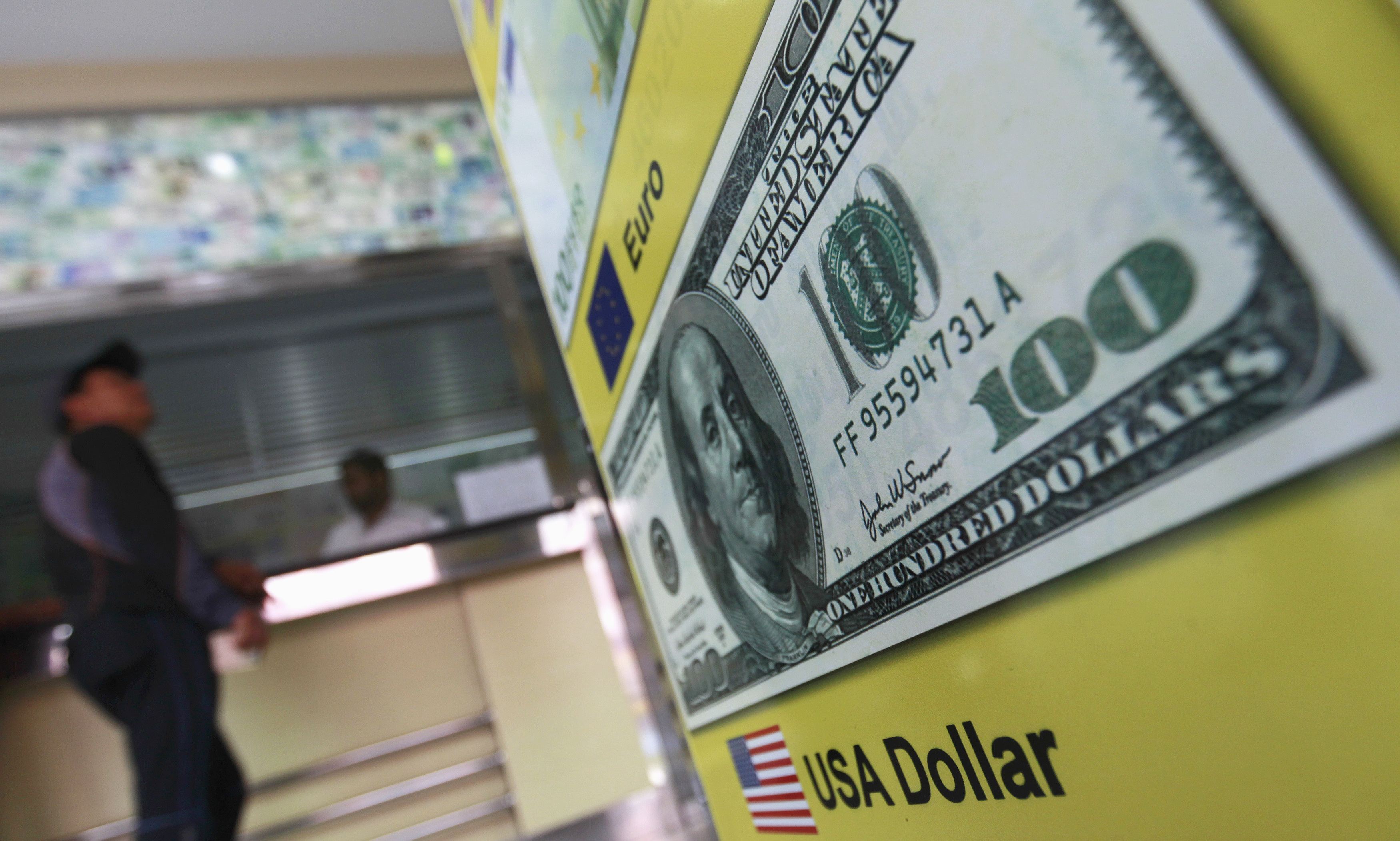 A man stands next to a money changer in Colombo