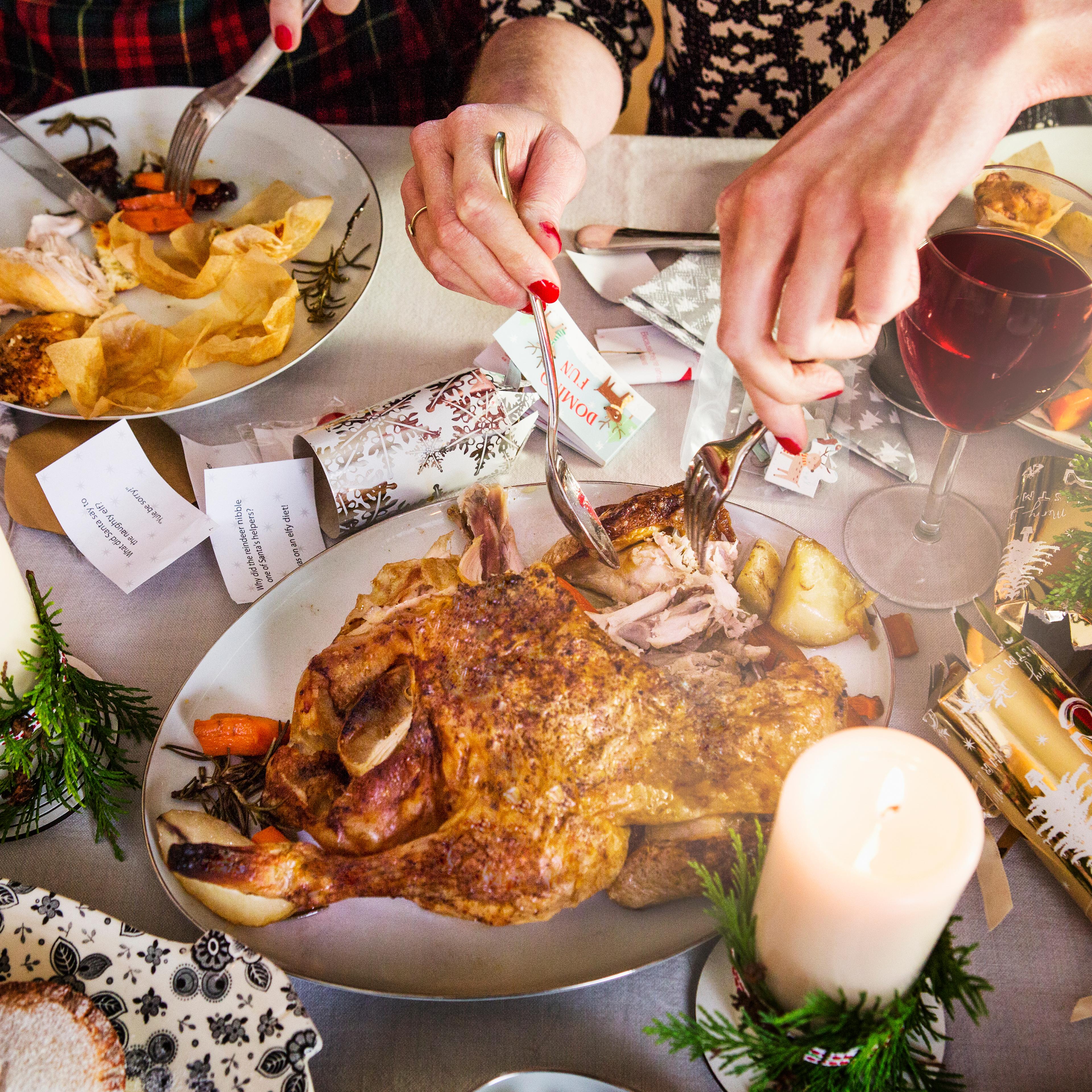 Close up of hands taking turkey and cutting food.