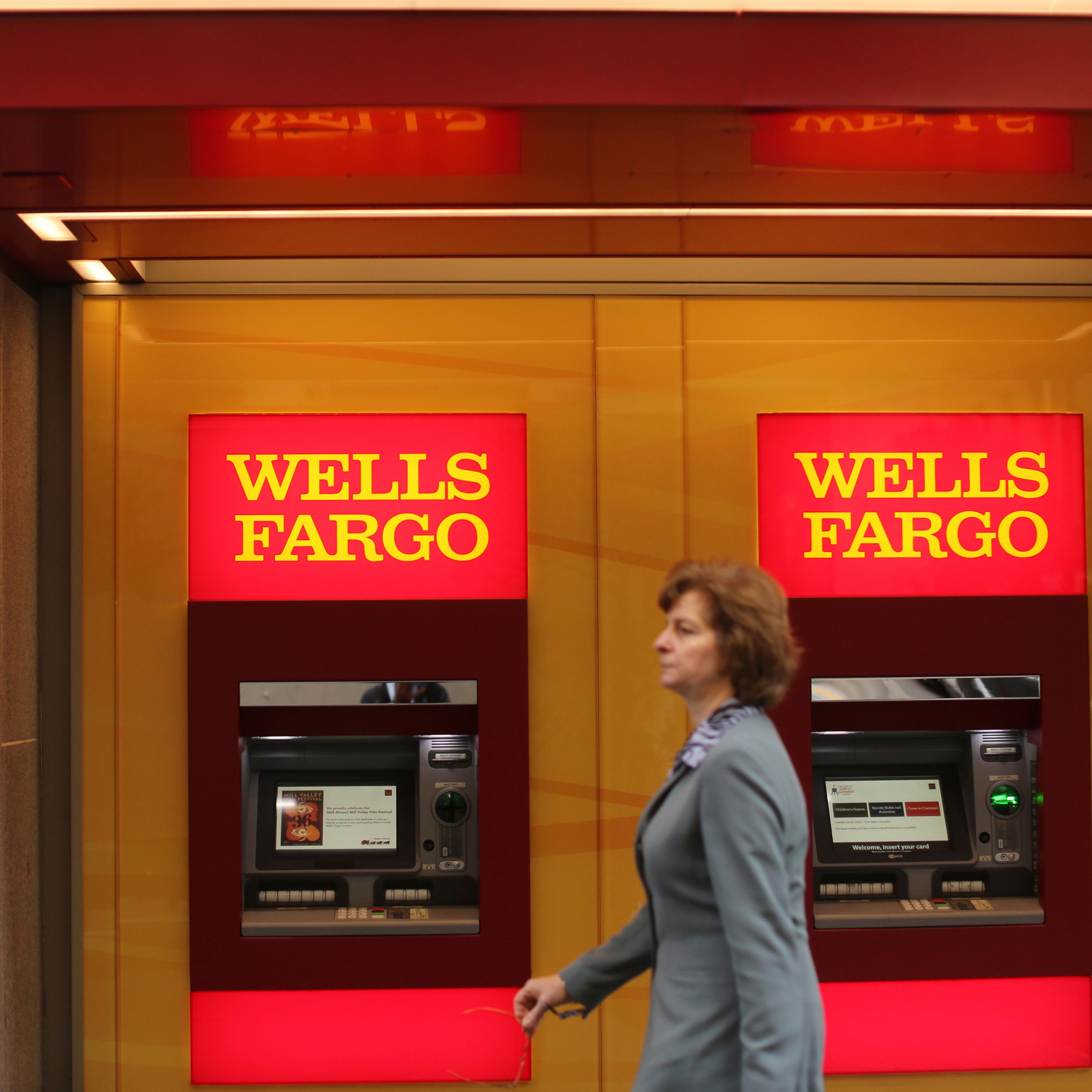 A woman walks past teller machines at a Wells Fargo bank in San Francisco, California.