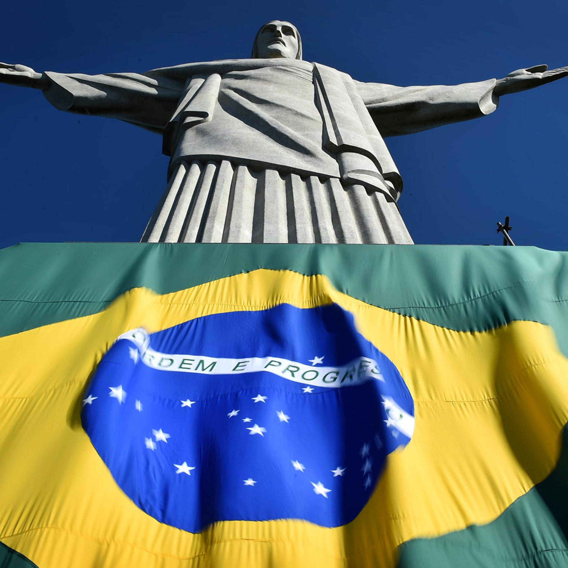 The Brazilian flag is seen at the base of the statue of the Christ the Redeemer on top of Corcovado hill in Rio de Janeiro, Brazil, on June 12, 2014
