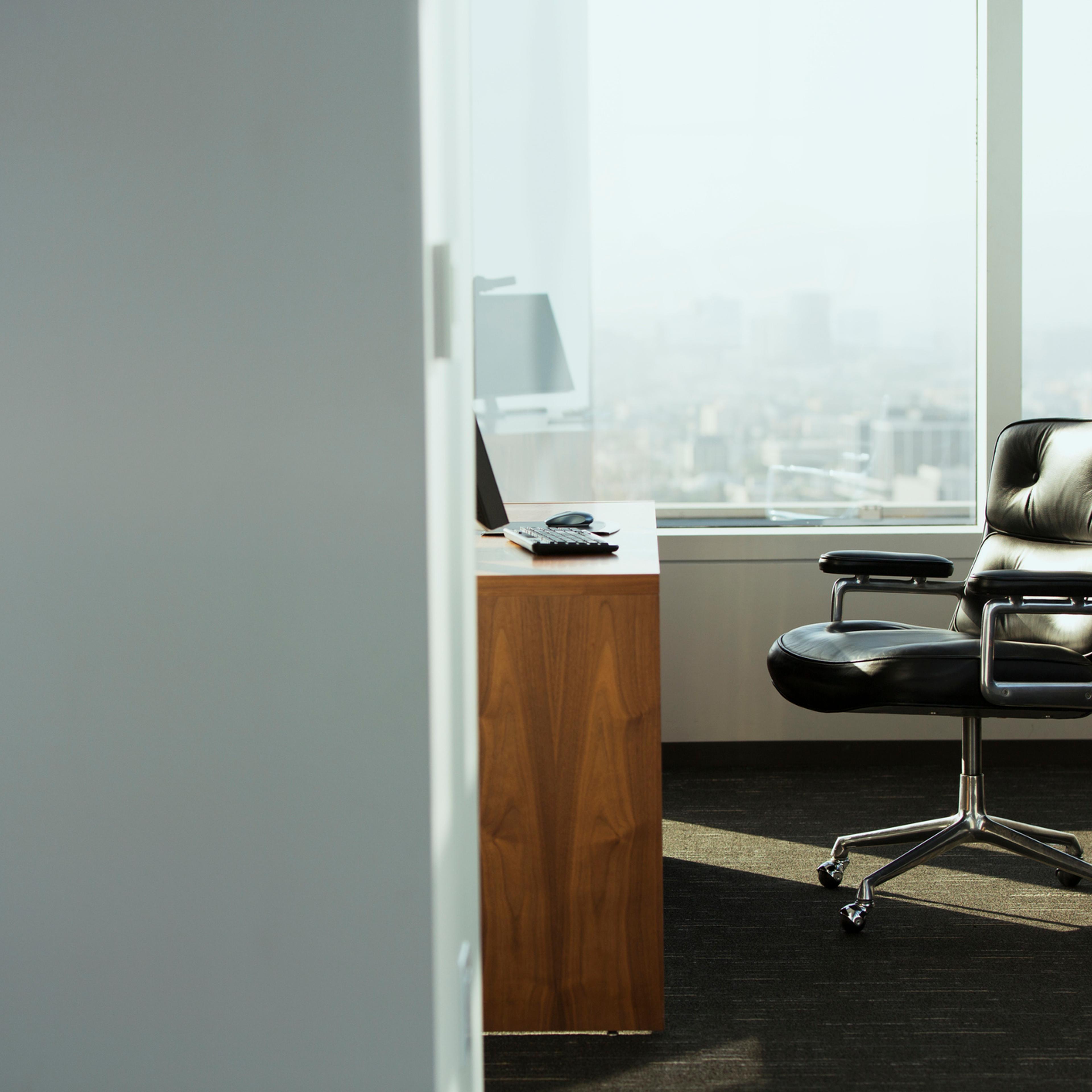 bright corner office space with desk and chairs