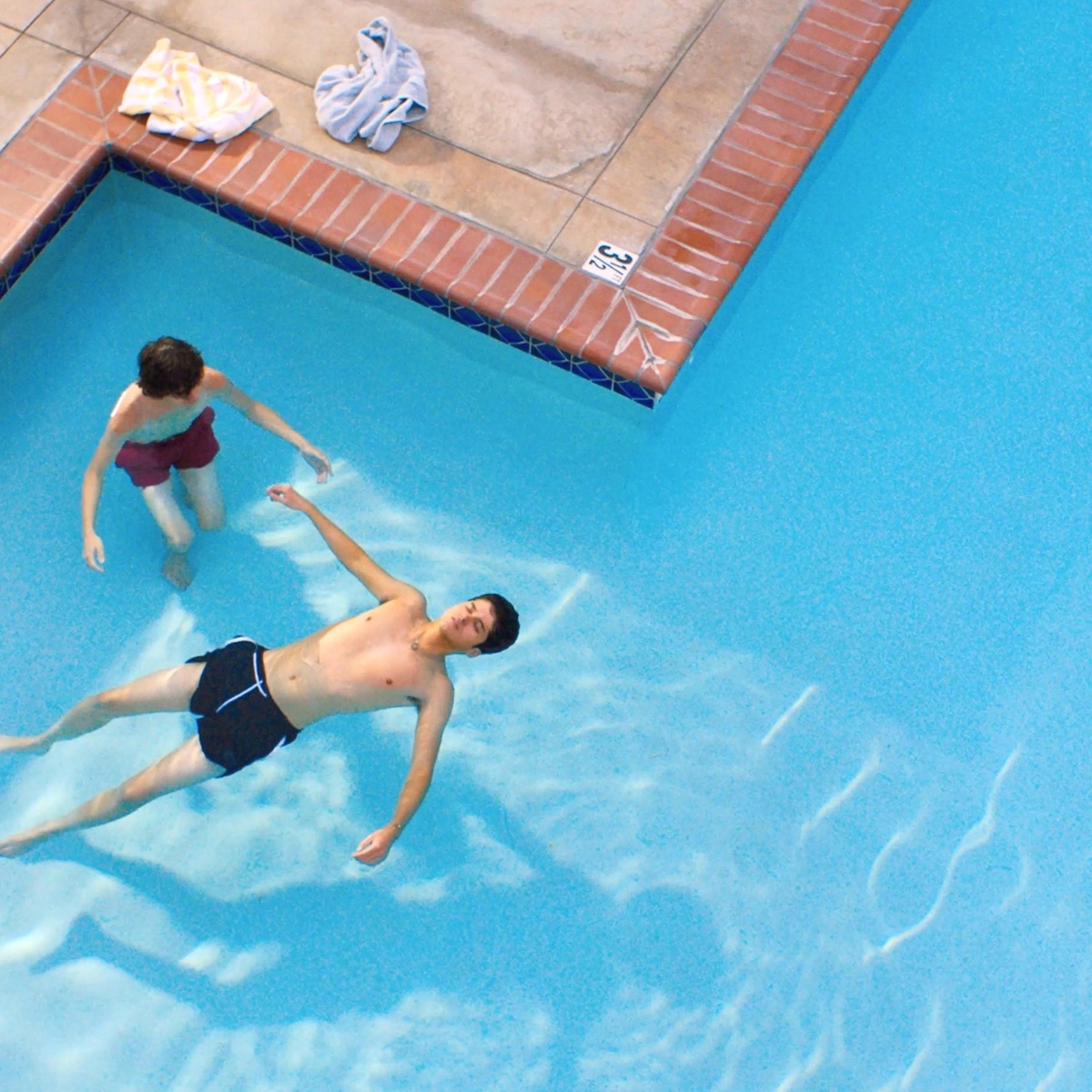 Dante (Reese Gonzales) teaches Ari (Max Pelayo) how to swim in a local pool.