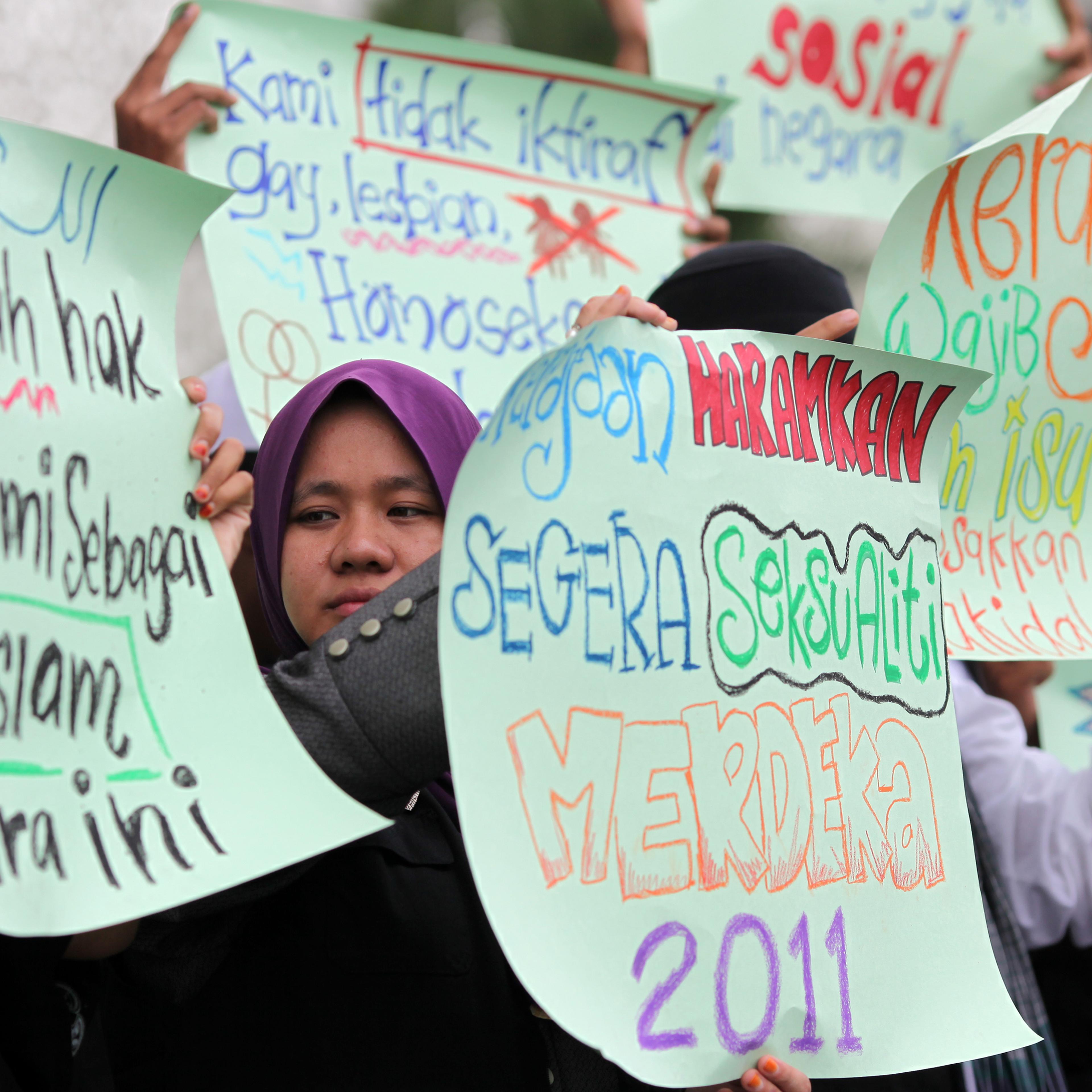 Protesters raise placards during a prote