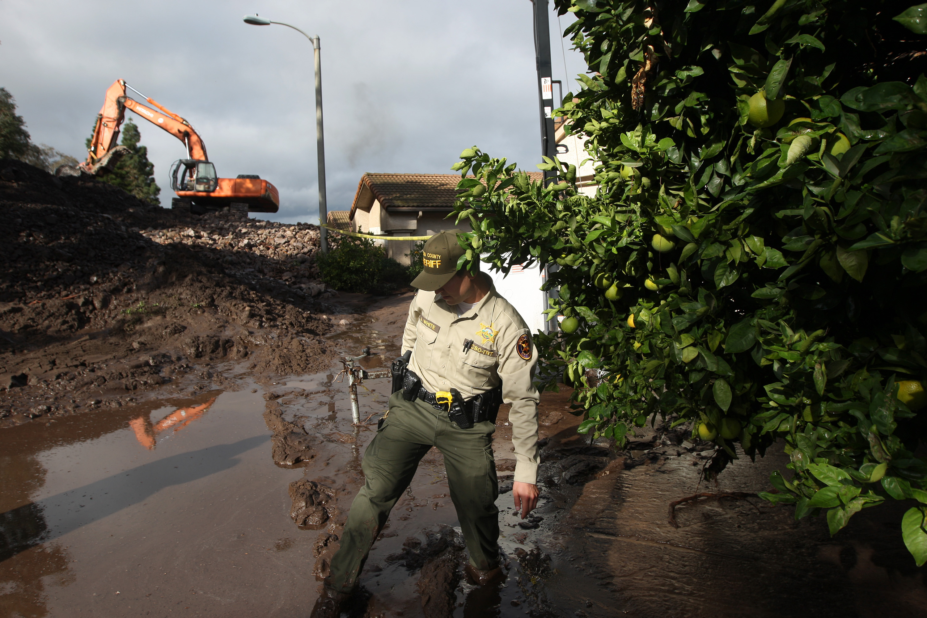 A Ventura County Sheriffs deputy walks through mud on Dec. 12, 2014 in Camarilla, California.