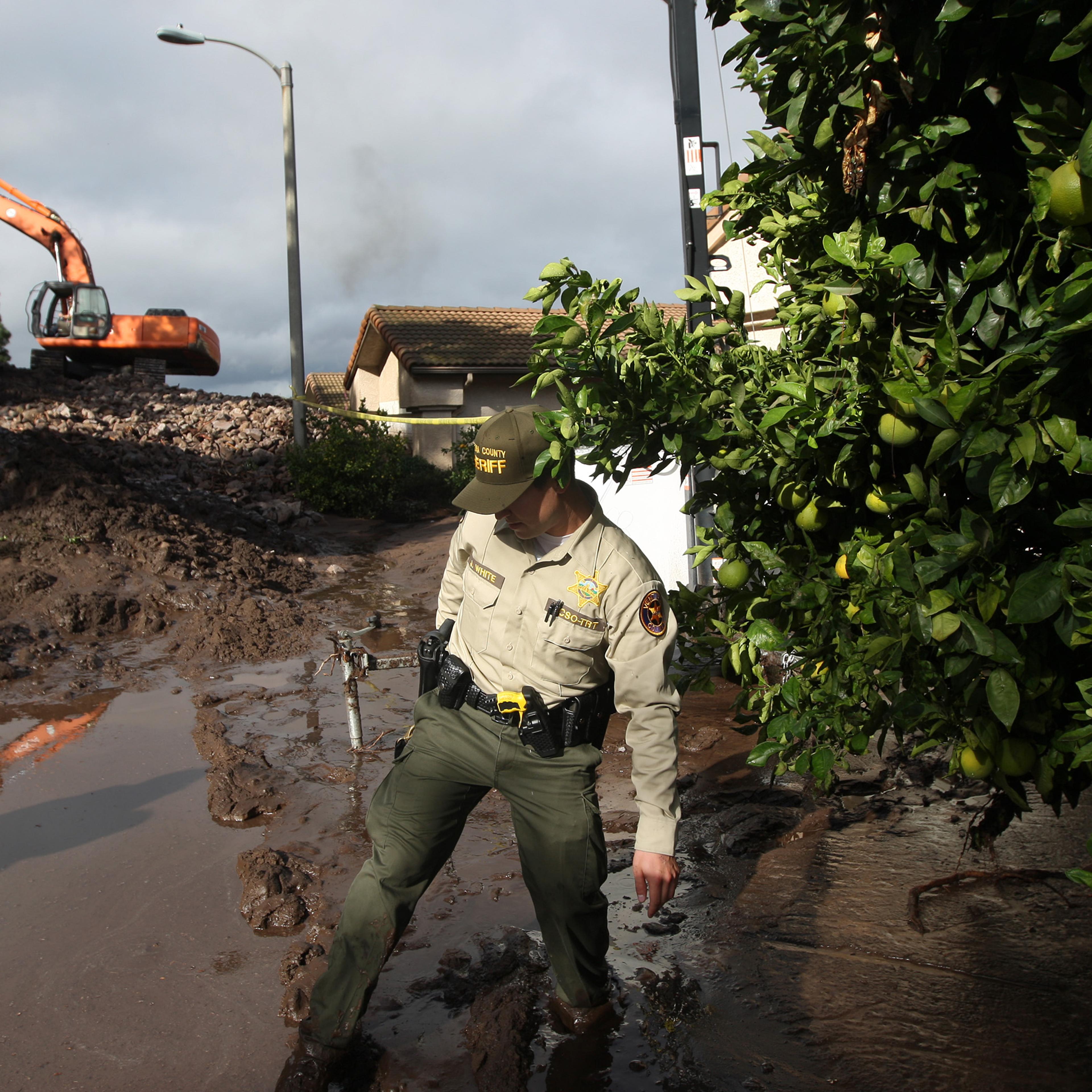A Ventura County Sheriffs deputy walks through mud on Dec. 12, 2014 in Camarilla, California.