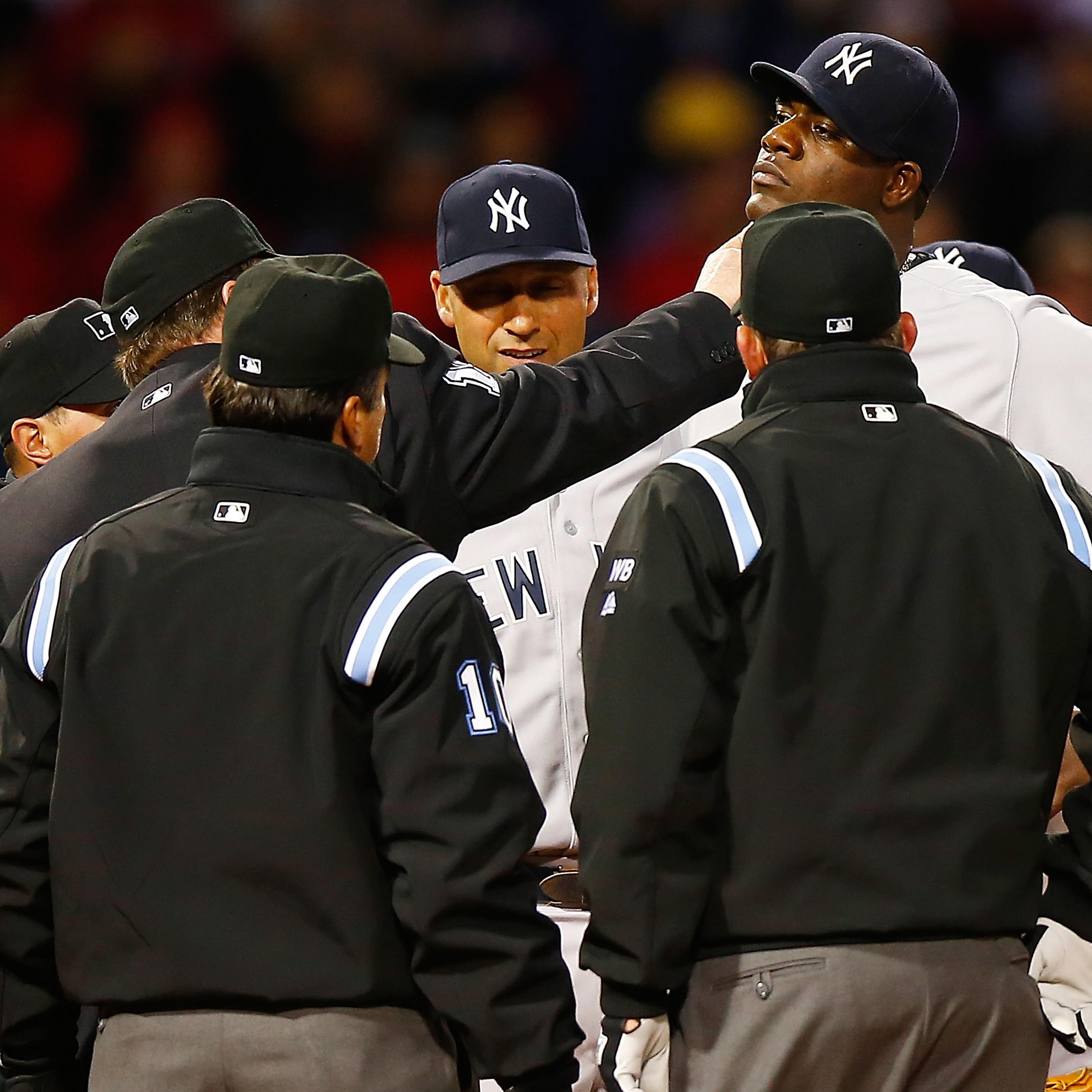 Umpires check Michael Pineda for a foreign substance as Derek Jeter looks on.