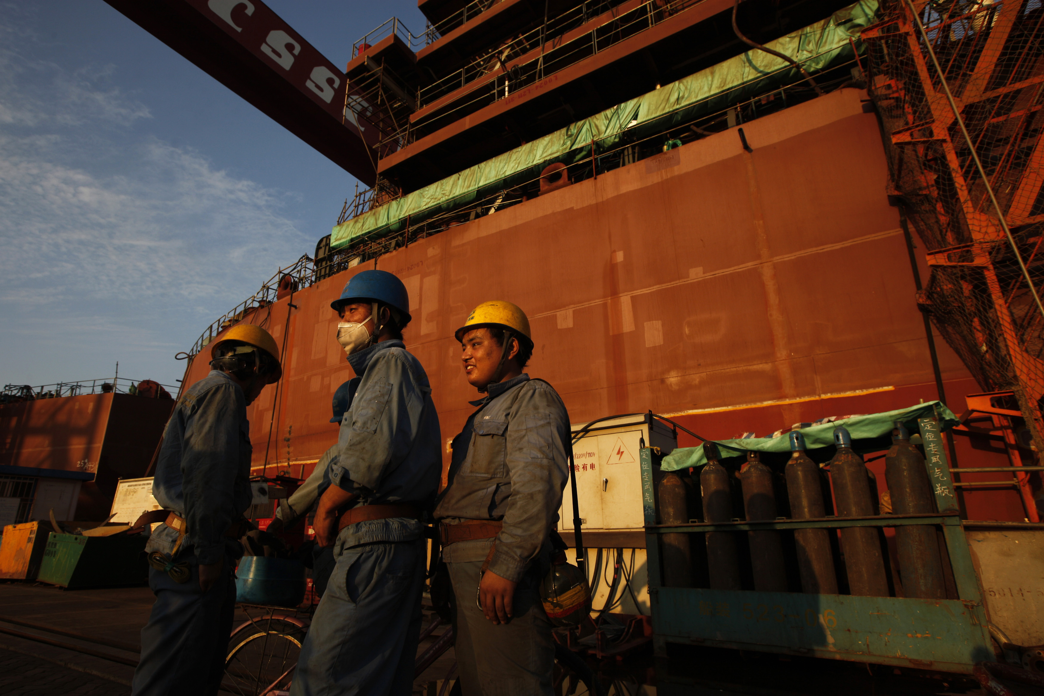 Employees stand in front of nearly completed ship at China State Shipbuilding Corporation (CSSC) Longxue shipbuilding ,in the southern Chinese city of Guangzhou