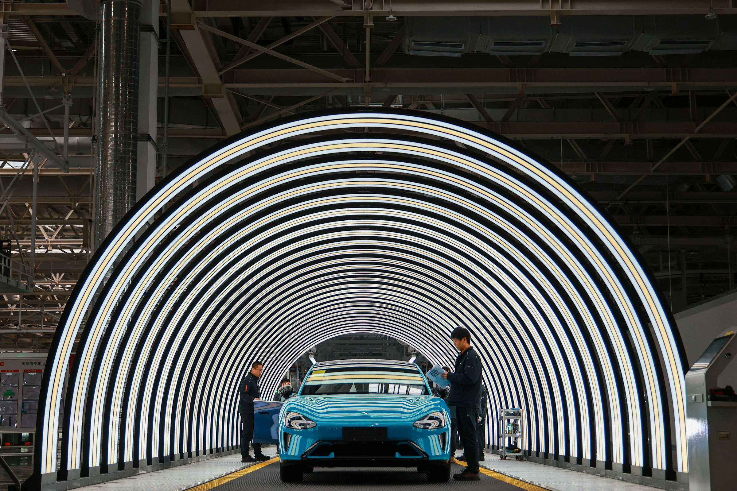 Employees work on the production line of electric vehicles at Xiaomi’s Electric Vehicle Factory in Beijing, on March 25, 2024.