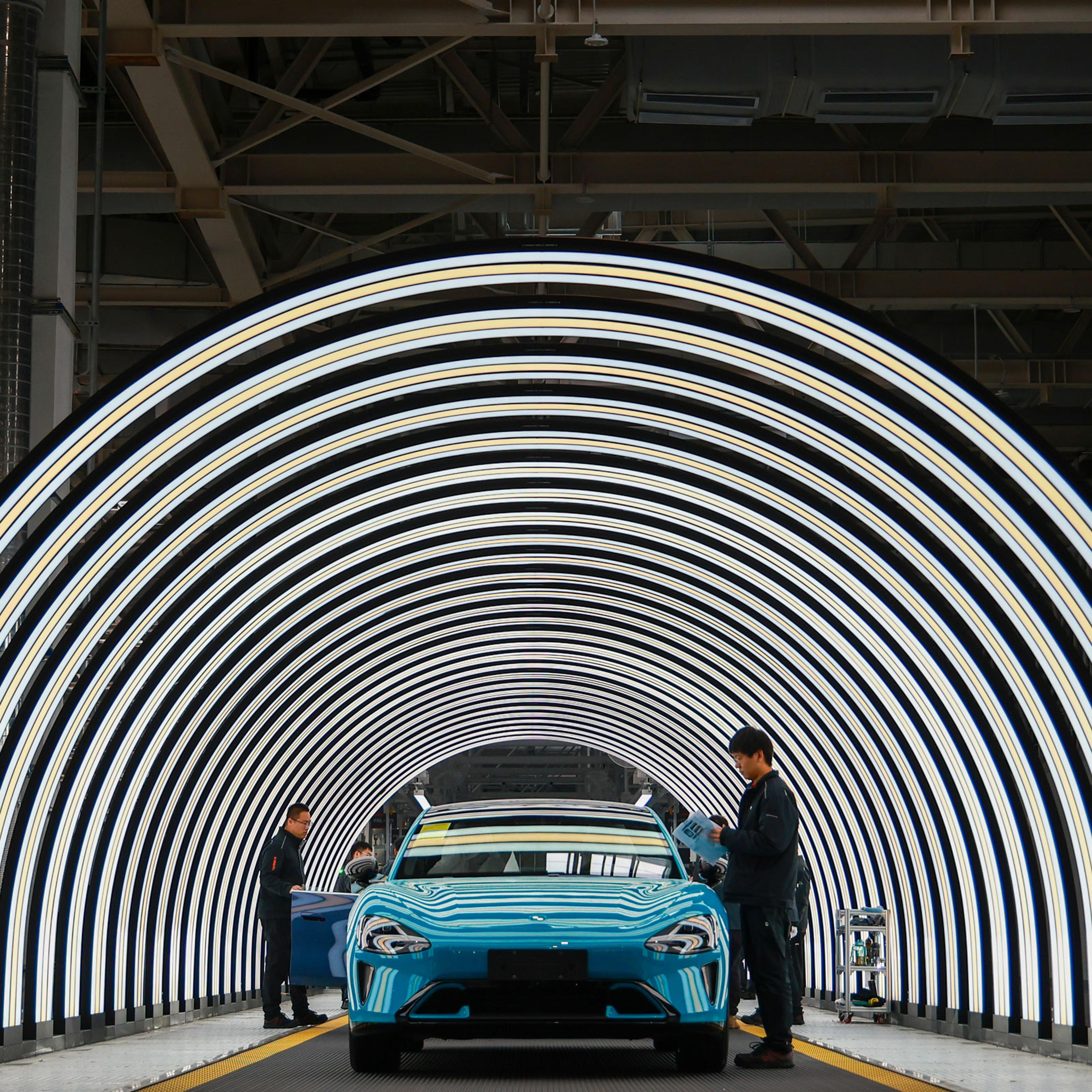 Employees work on the production line of electric vehicles at Xiaomi’s Electric Vehicle Factory in Beijing, on March 25, 2024.