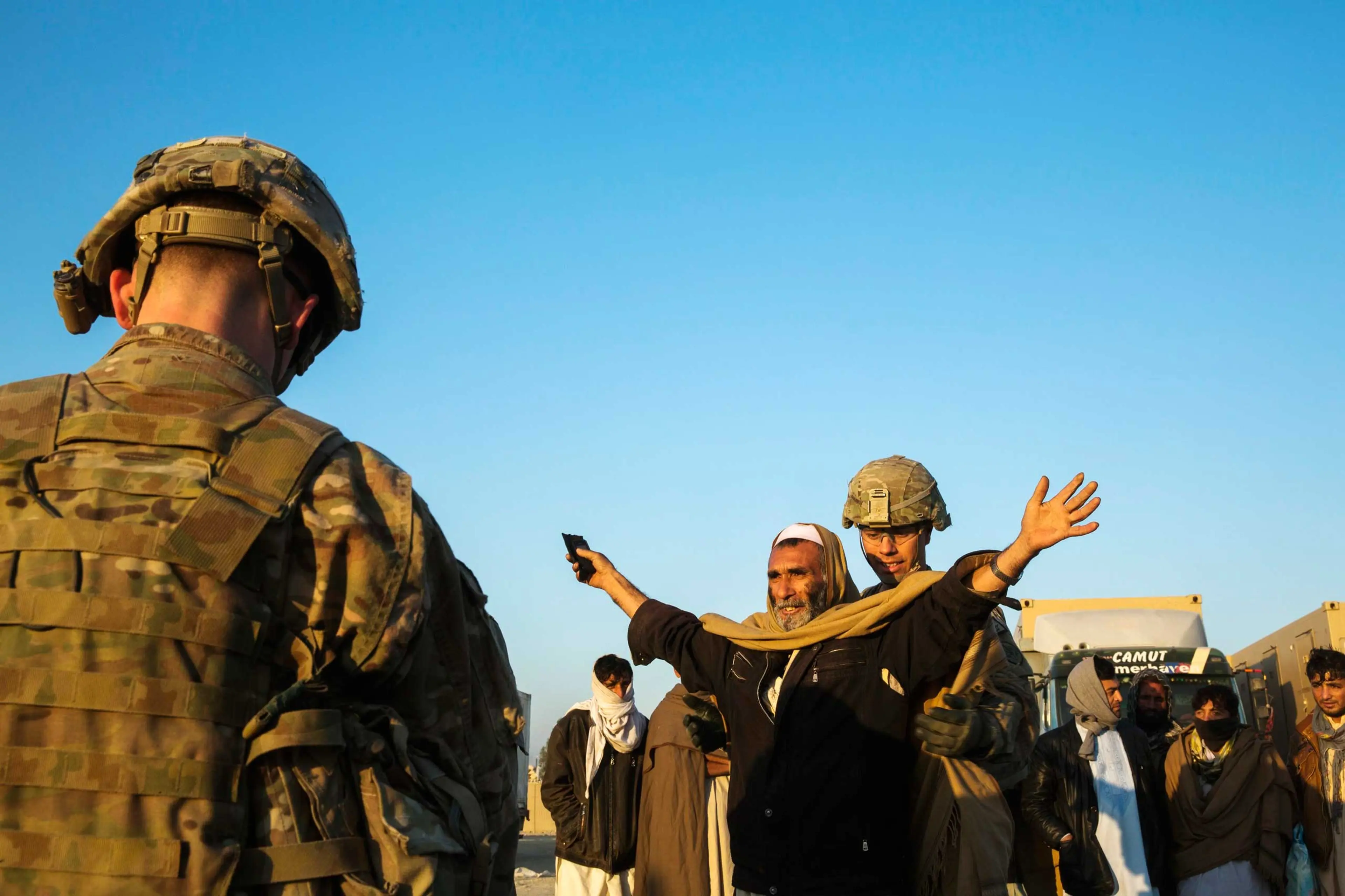 U.S. soldiers from 3rd Cavalry Regiment interact with men selected to be biometrically screened near forward operating base Gamberi in the Laghman province of Afghanistan