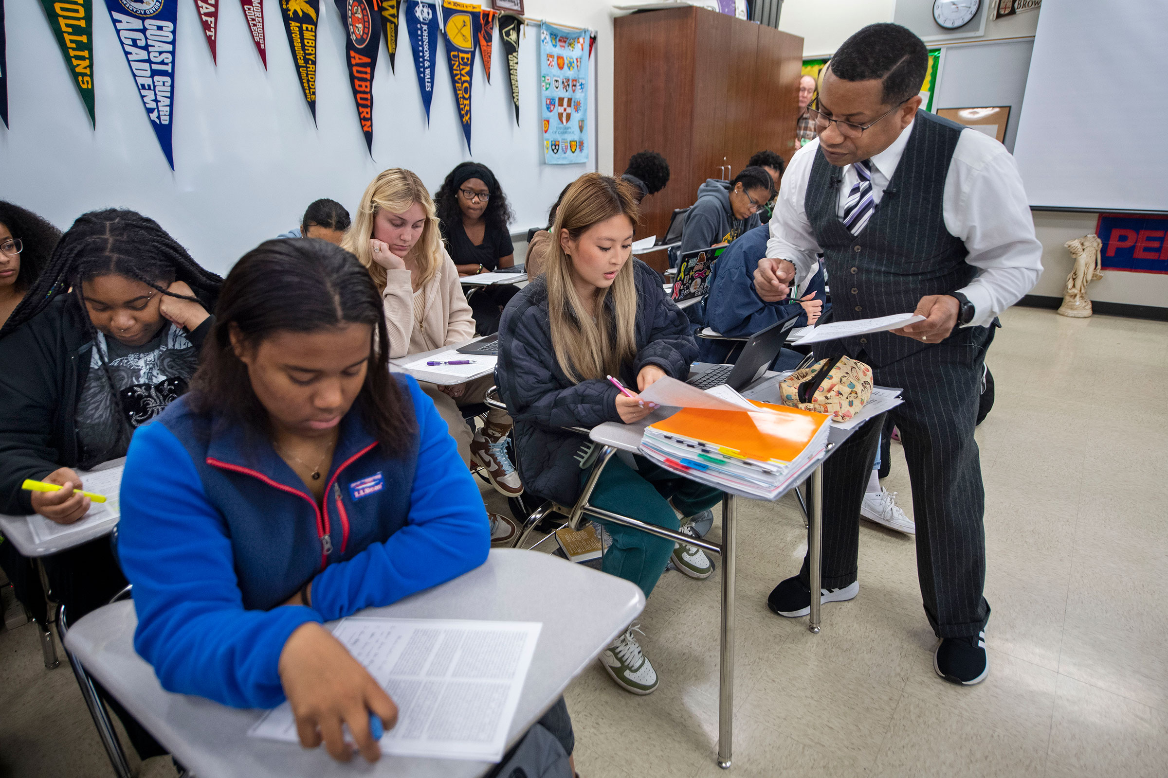 Baton Rouge Magnet High School teacher Emmitt Glynn III, right, talks with Neena Webb, 17, center, in class with other students including, from left, Amilya Franklin, 18, Bailey Bunch, 18, and Hannah Landry, 17, Friday, Feb. 17, 2023, as he teaches a new