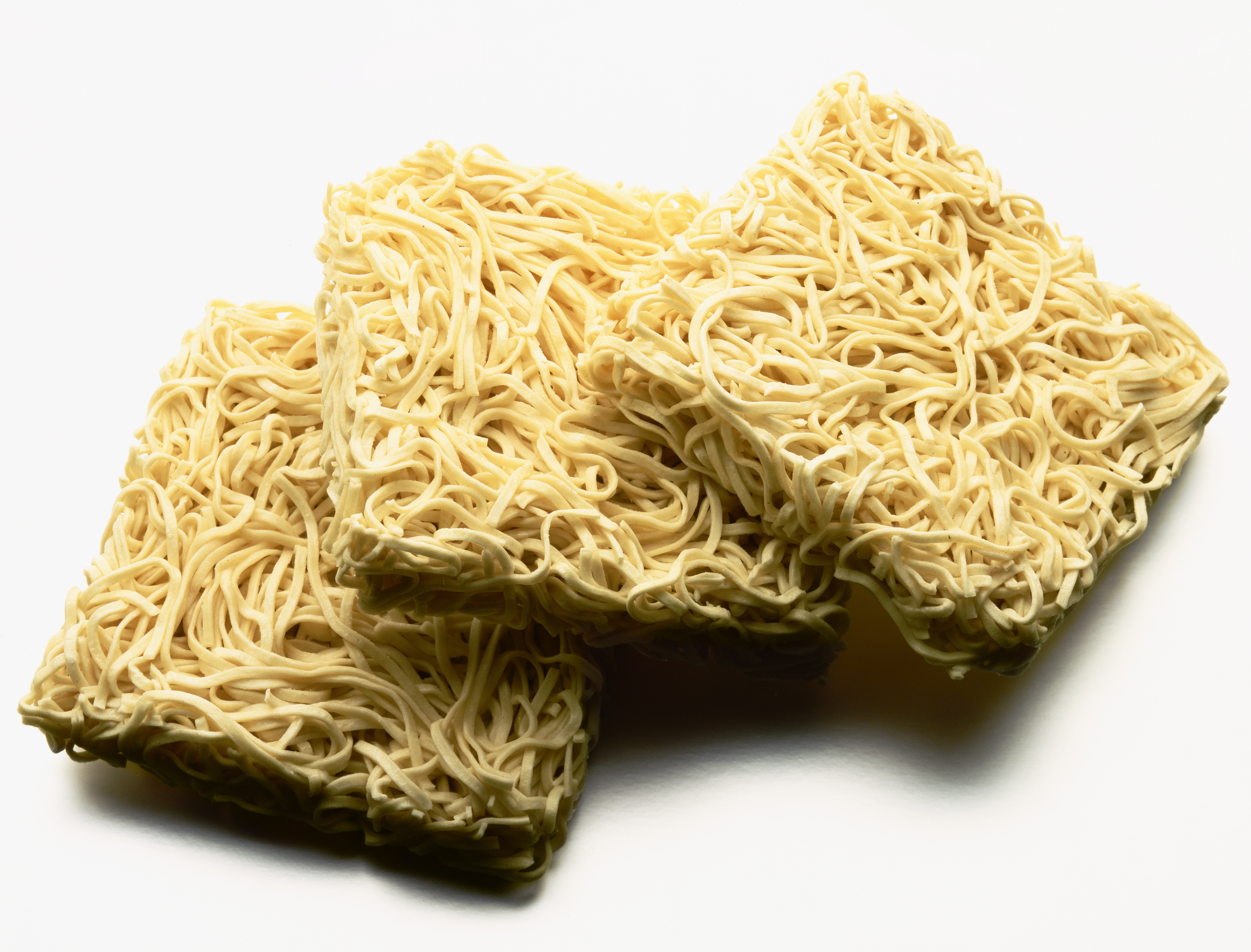 Dry egg noodles against white background, close-up