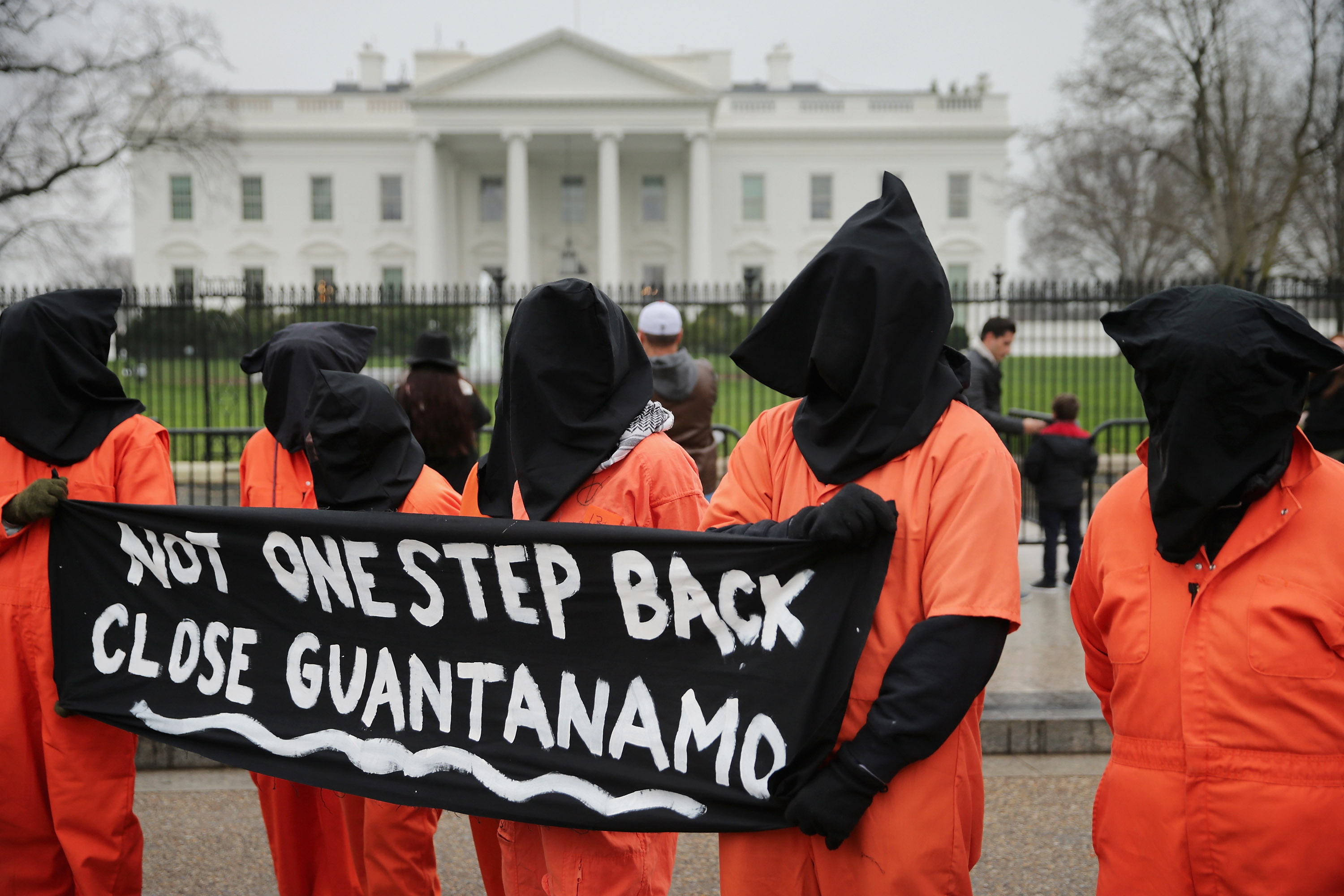 Demonstrators with the group Witness Against Torture dress in orange jumpsuits and wear black hoods while demanding that U.S. President Barack Obama close the military prison in Guantanamo, Cuba, outside the White House in Washington, DC.. on Jan. 8, 201