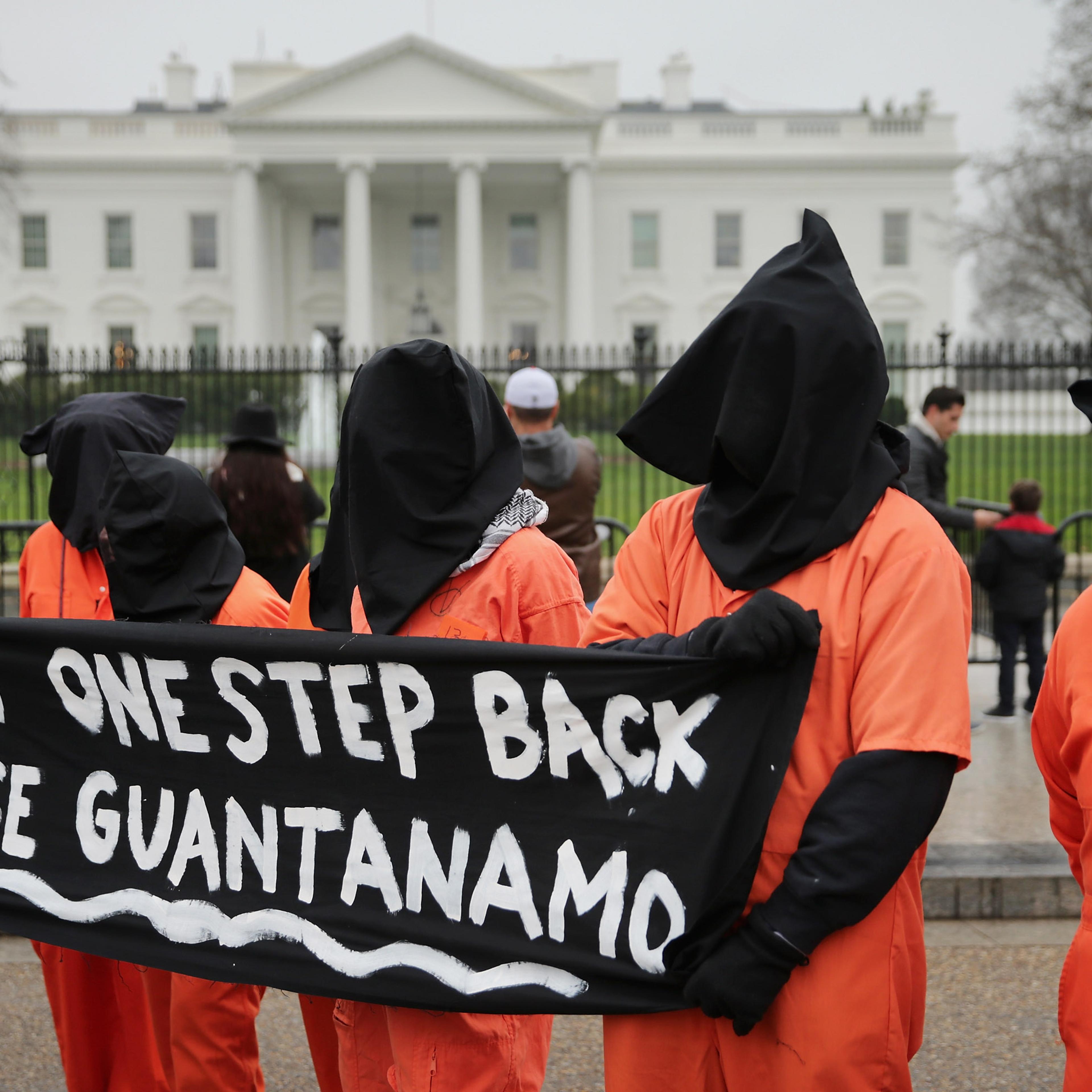 Demonstrators with the group Witness Against Torture dress in orange jumpsuits and wear black hoods while demanding that U.S. President Barack Obama close the military prison in Guantanamo, Cuba, outside the White House in Washington, DC.. on Jan. 8, 201