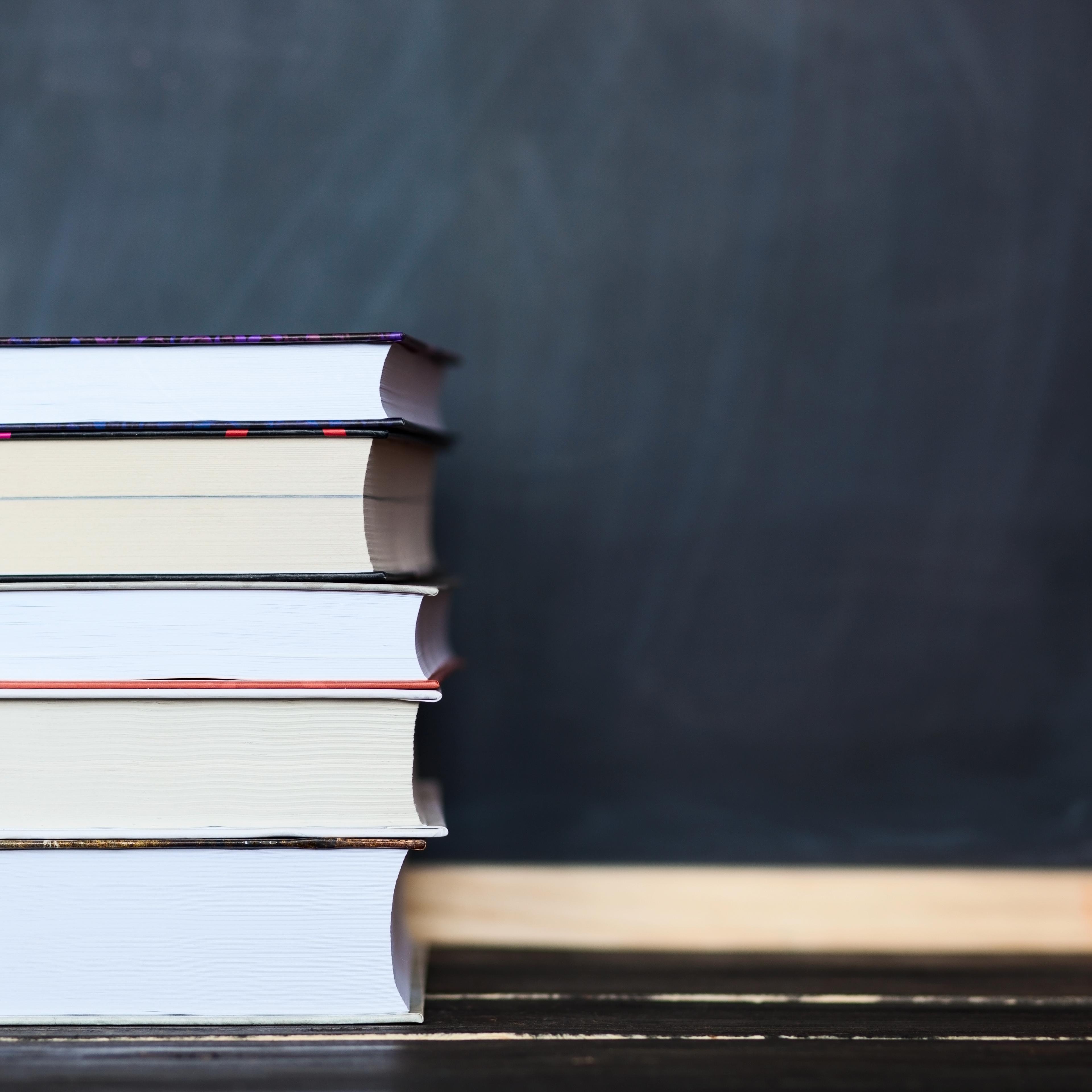 Stack of books with chalkboard in background . Space for your text