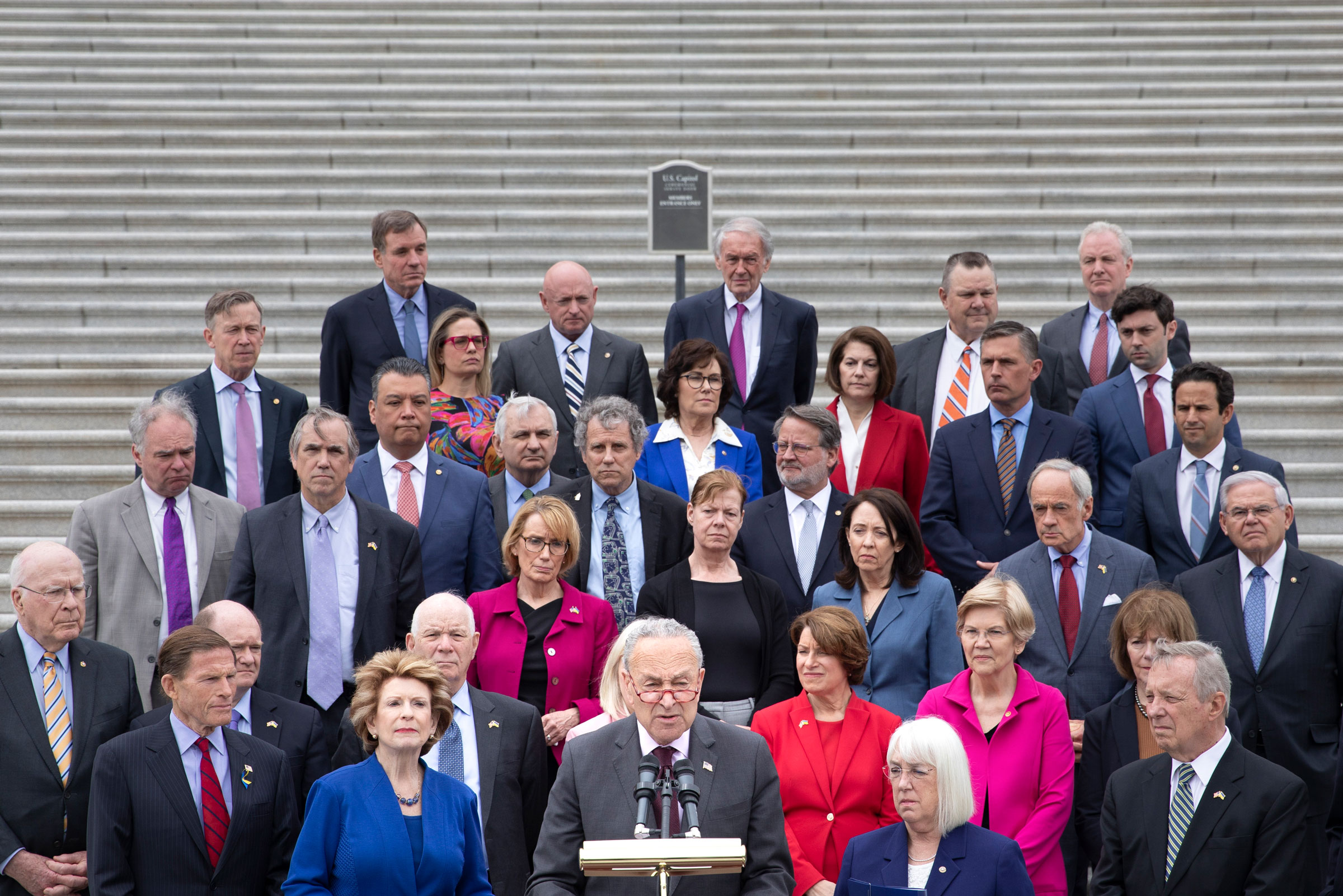 Chuck Schumer (D-N.Y.), surrounded by fellow Democrats, makes a statement on the Supreme Court outside the Senate steps
