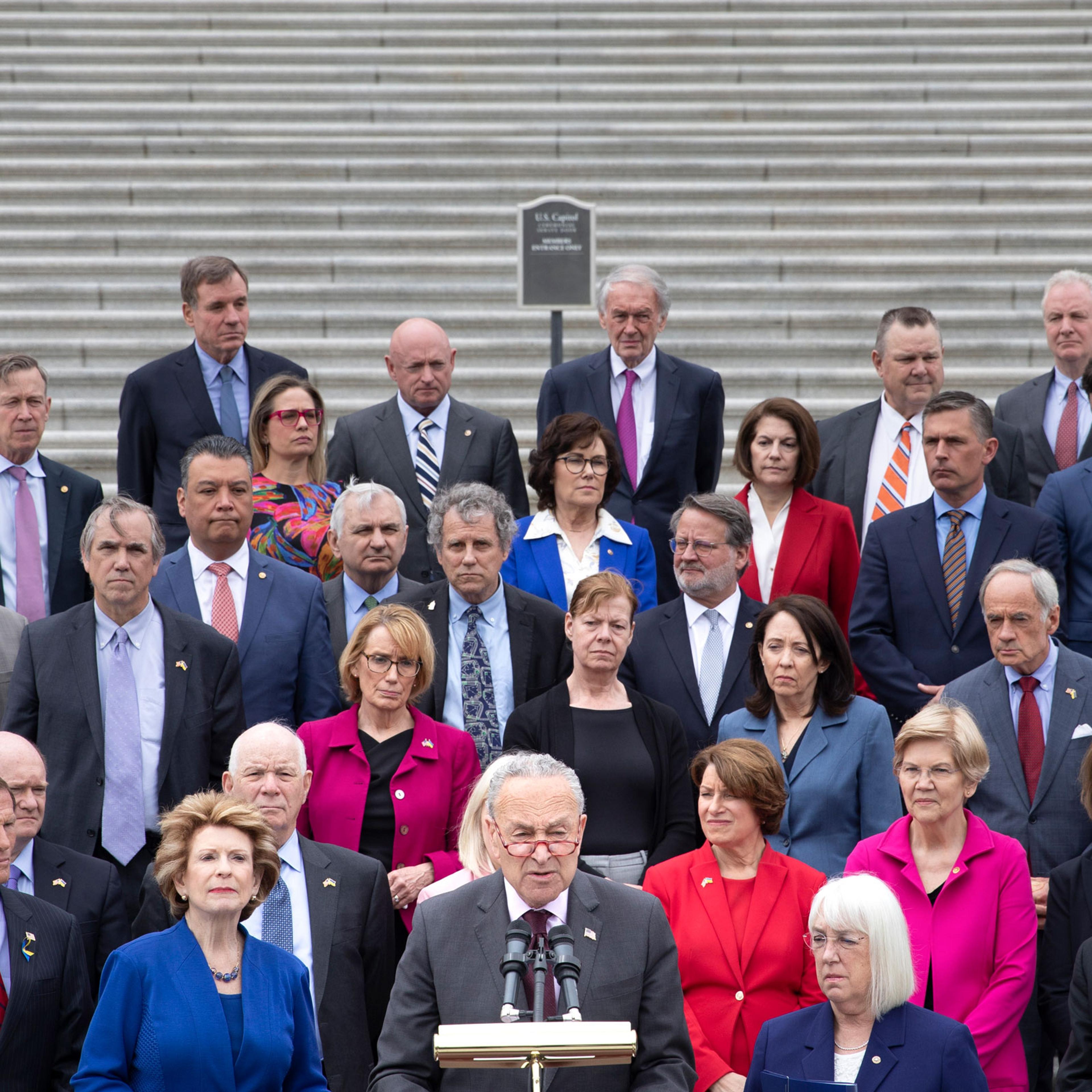 Chuck Schumer (D-N.Y.), surrounded by fellow Democrats, makes a statement on the Supreme Court outside the Senate steps