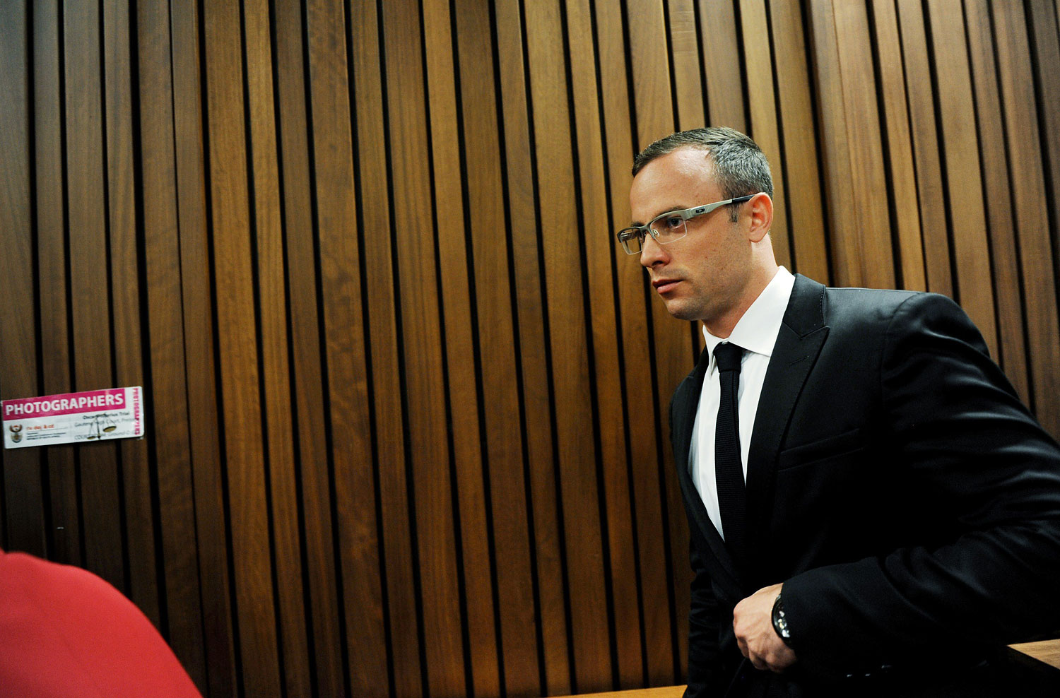 Paralympian Oscar Pistorius exits the courtroom after his murder trial was postponed at the high court in Pretoria on March 28, 2014.