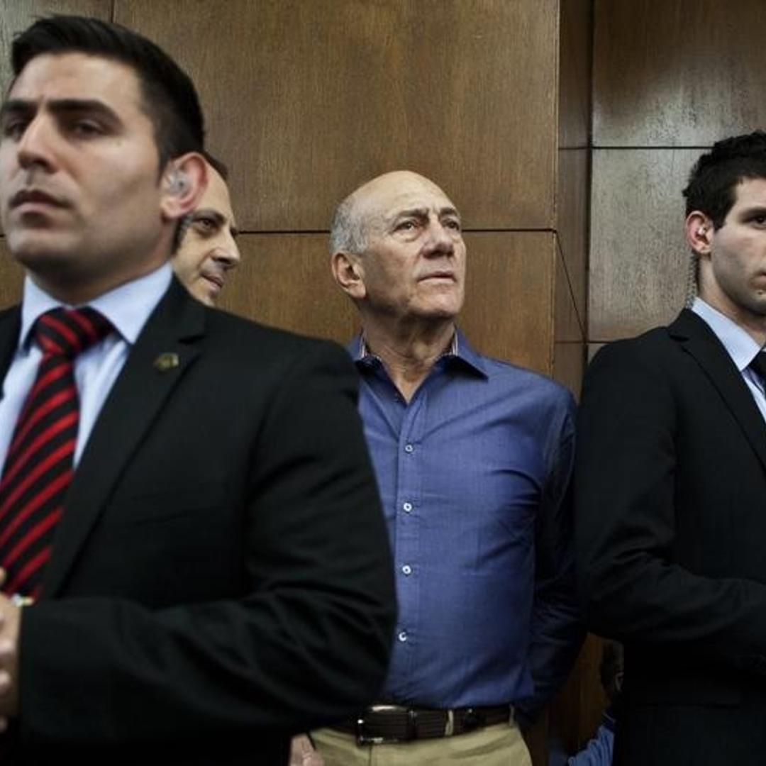 Former Israeli Prime Minister Ehud Olmert (center) waits to hear his verdict at the Tel Aviv District Court on March 31, 2014.