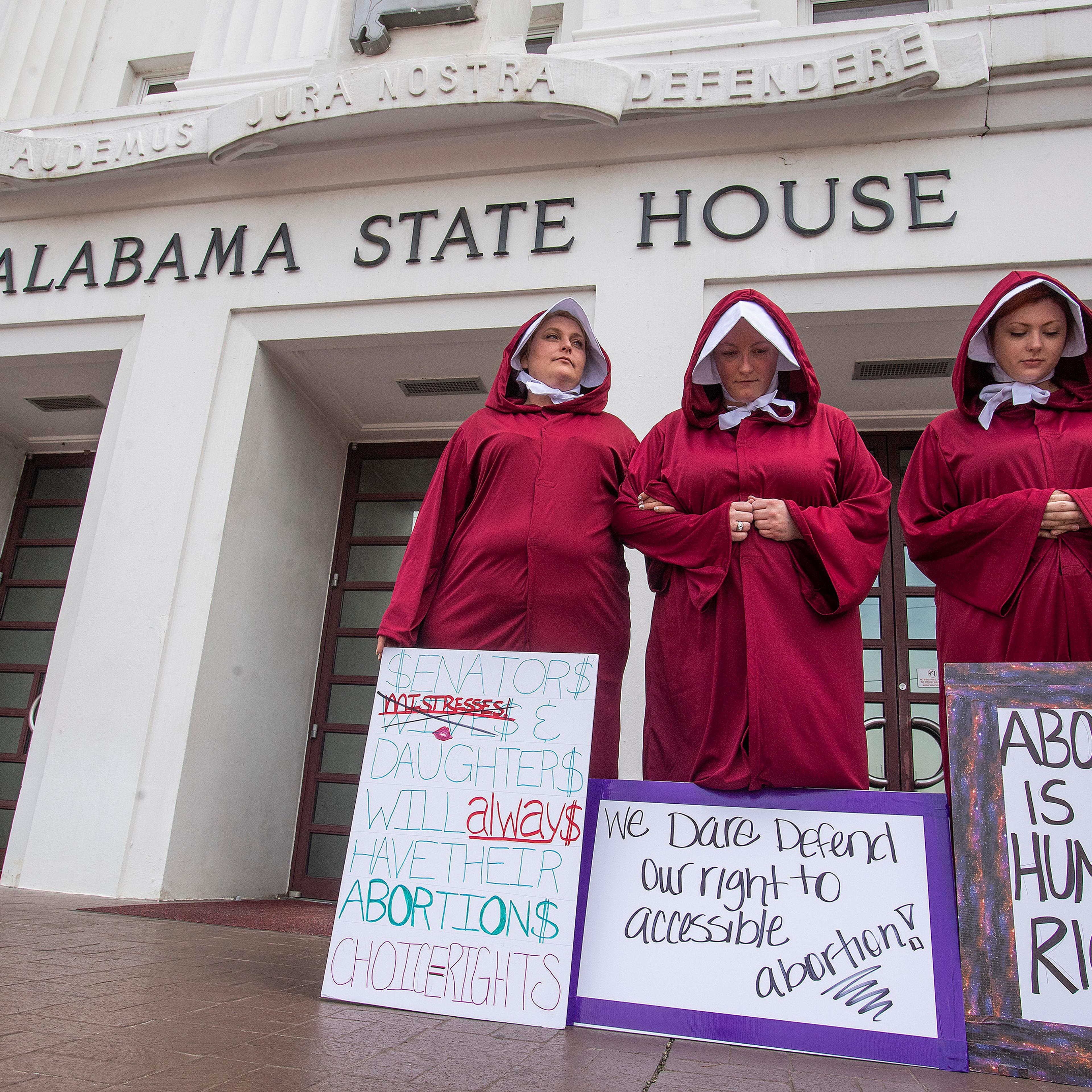 Women take part in a protest against HB314, the abortion ban bill, at the Alabama State House