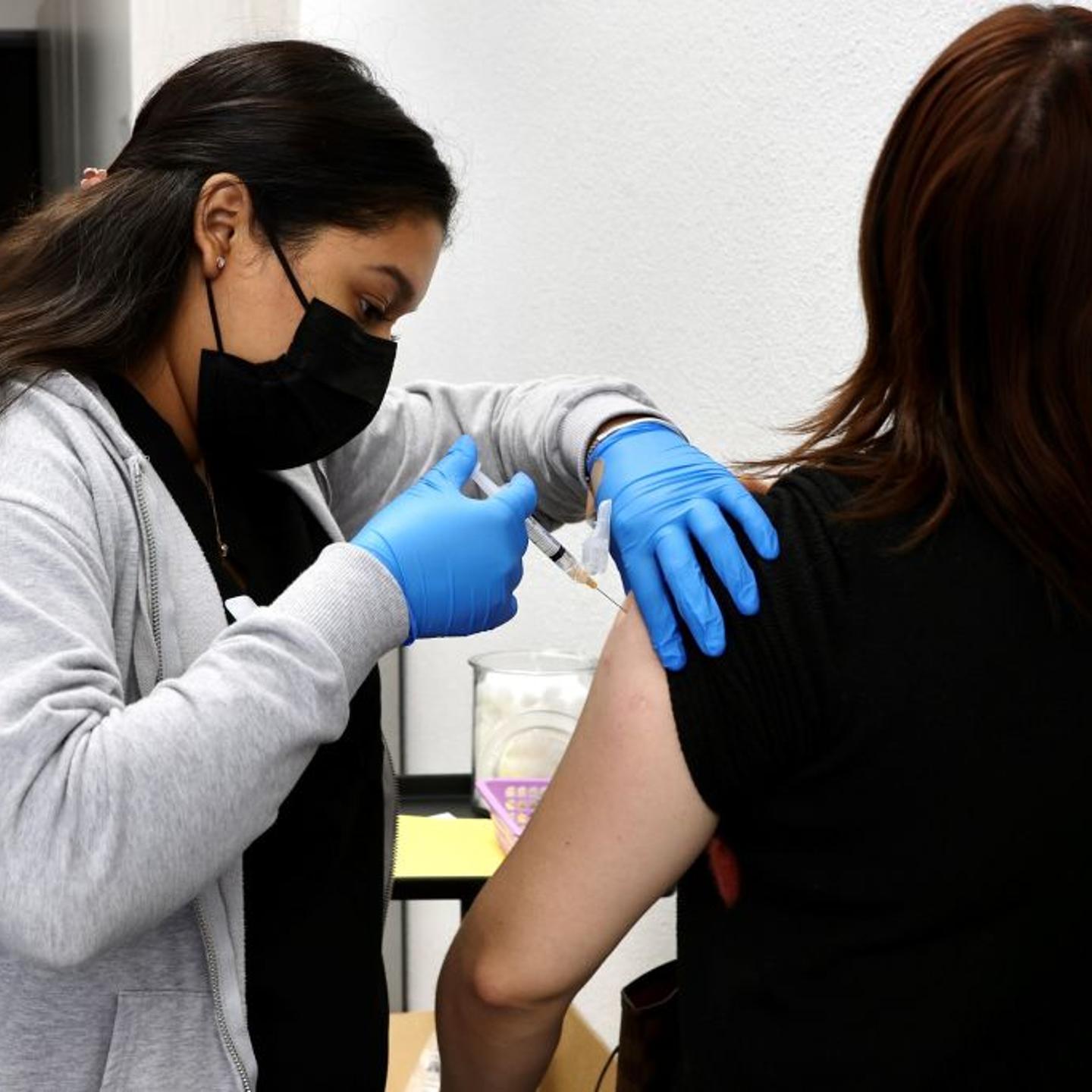 A health care worker administers a flu shot