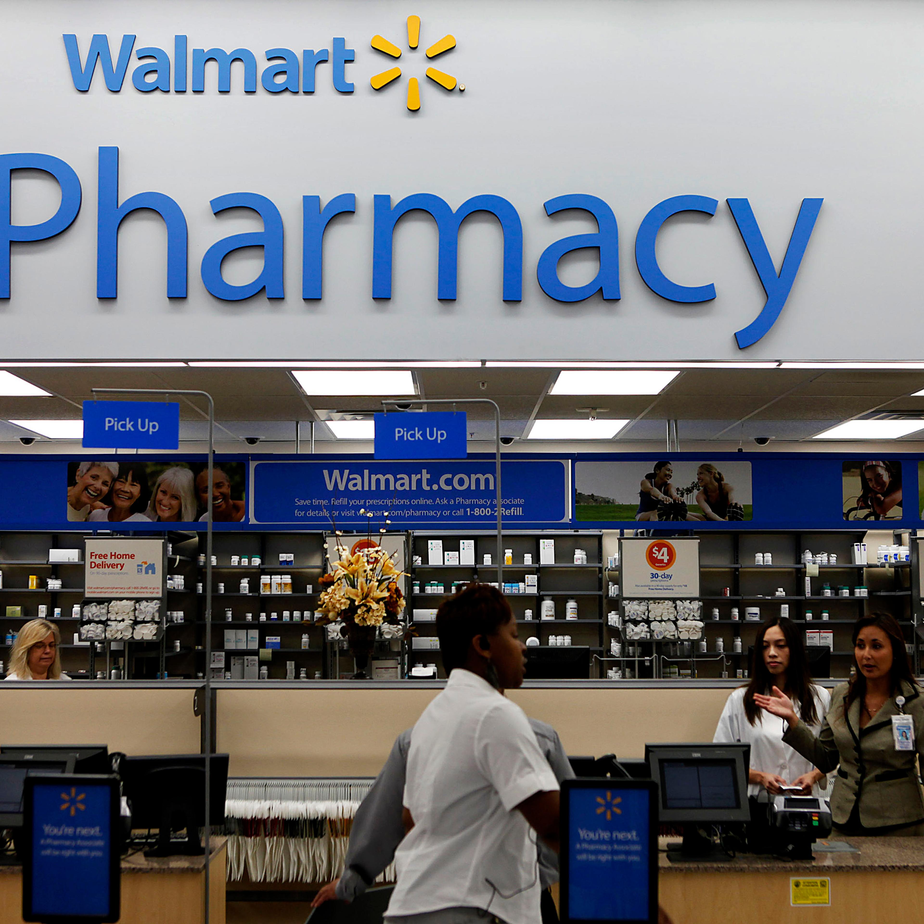 A customer walks past the pharmacy during the grand opening of a new Wal-Mart Stores Inc. location in Torrance, California, U.S., on Wednesday, Sept. 12, 2012