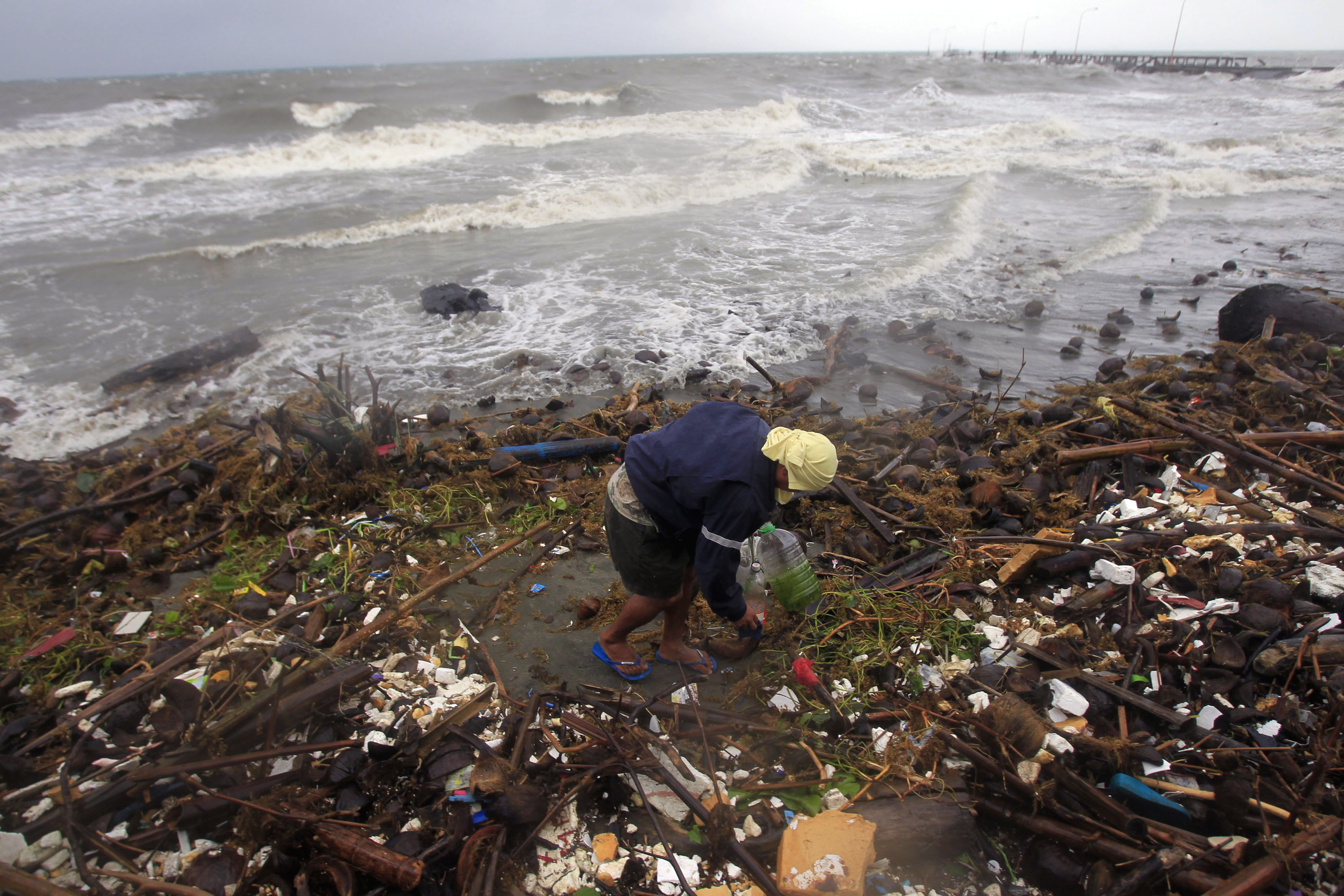 A resident looks for a recyclable material at a port, after heavy rain and strong winds brought by typhoon Hagupit battered Atimonan town