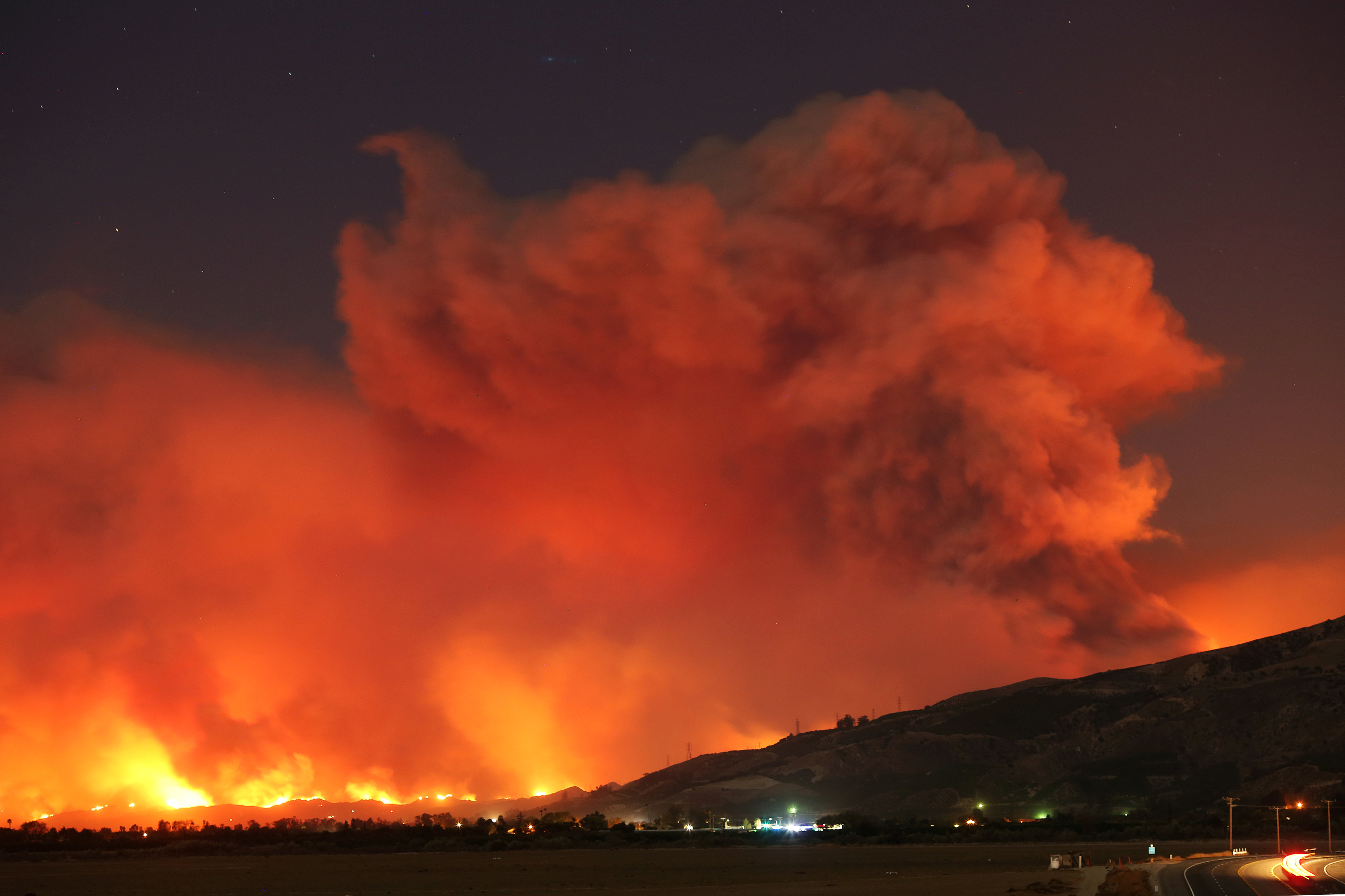 Smoke rises into the night sky as strong winds push the Thomas Fire across thousands of acres near Santa Paula