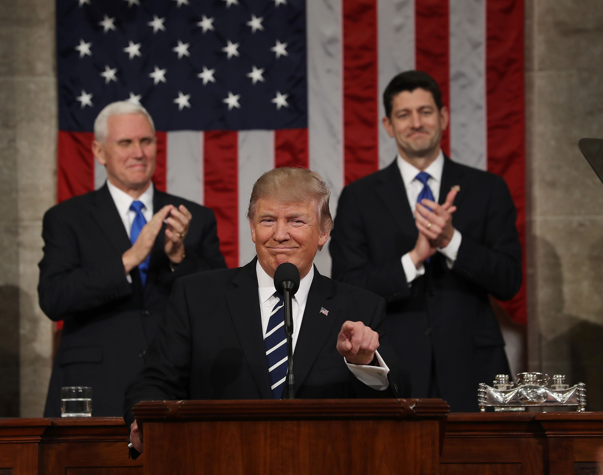 US Vice President Mike Pence (L) and Speaker of the House Paul Ryan (R) applaud as US President Donald J. Trump (C) arrives to deliver his first address to a joint session of Congress from the floor of the House of Representatives in Washington, DC, USA,