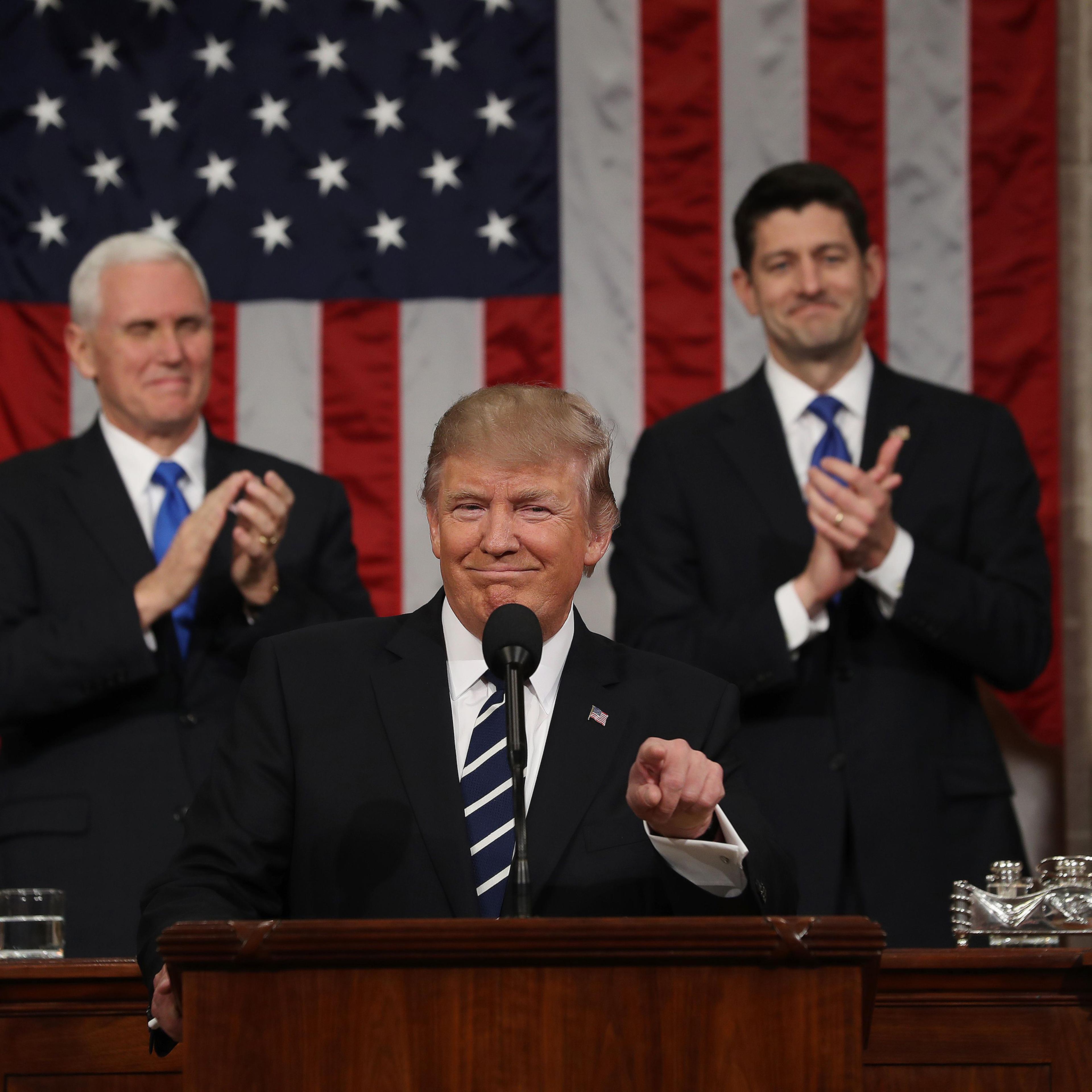US Vice President Mike Pence (L) and Speaker of the House Paul Ryan (R) applaud as US President Donald J. Trump (C) arrives to deliver his first address to a joint session of Congress from the floor of the House of Representatives in Washington, DC, USA,