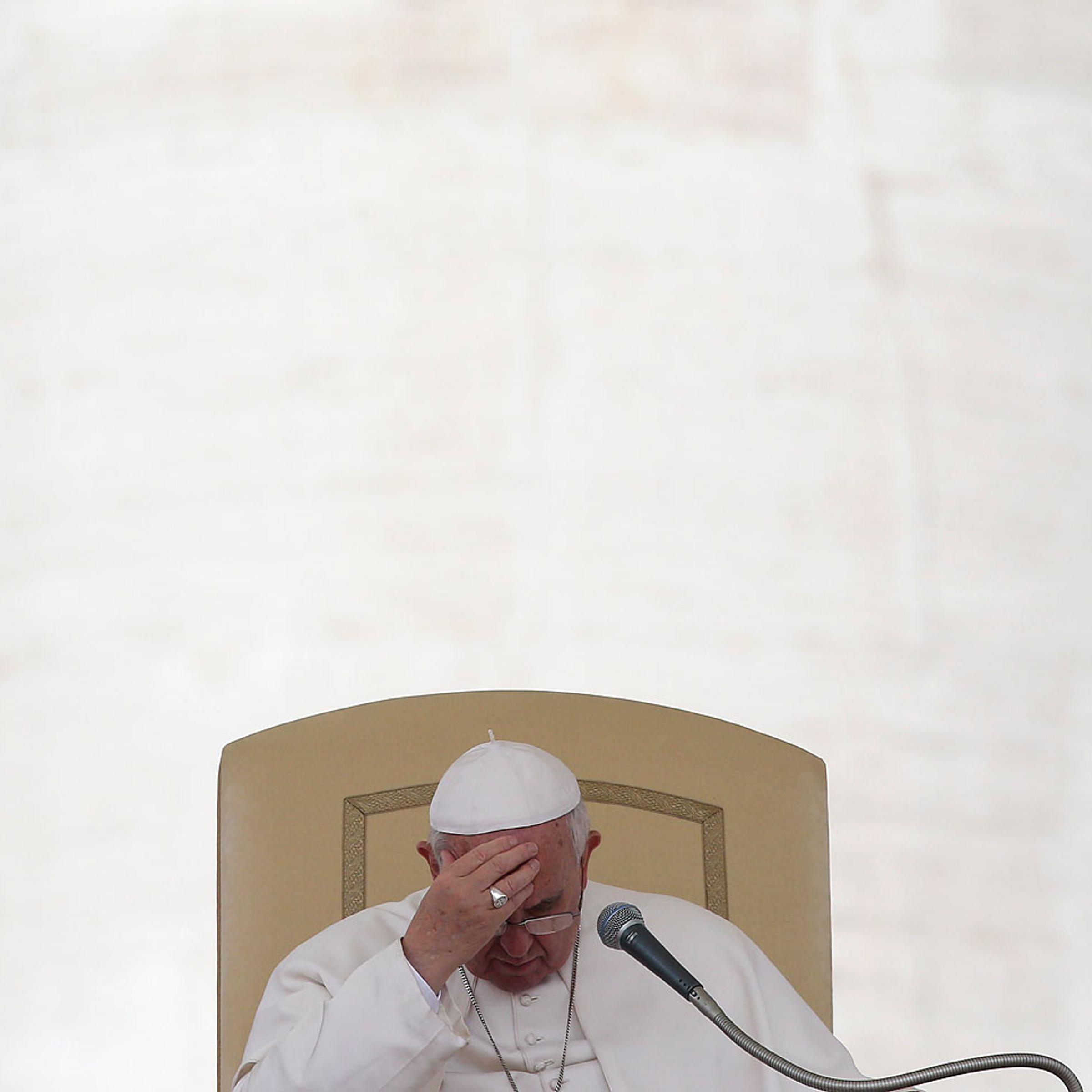 Pope Francis touches his forehead as he leads the general audience in Saint Peter's square at the Vatican, April 9, 2014.