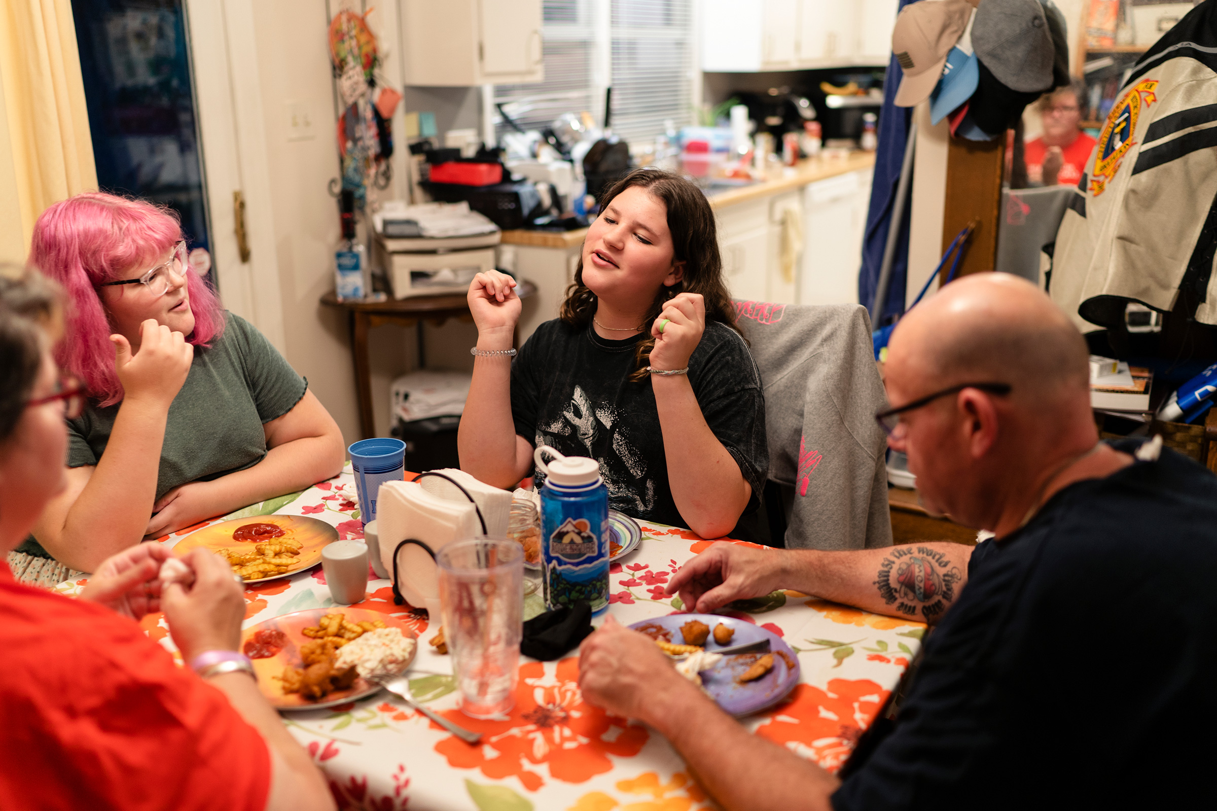Maddie, 15, right center, eats dinner with her family in North Carolina. “My family is my whole life,” Maddie says. Whenever they have to make a decision, she says, they always consider how it will impact all four of them. “I love that for us,” she says.