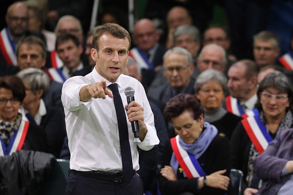 French President Emmanuel Macron (L) gestures as he speaks during meeting gathering some 600 mayors who will relay the concerns aired by residents in their towns and villages in the Normandy city of Grand Bourgtheroulde on January 15, 2019, as part of th