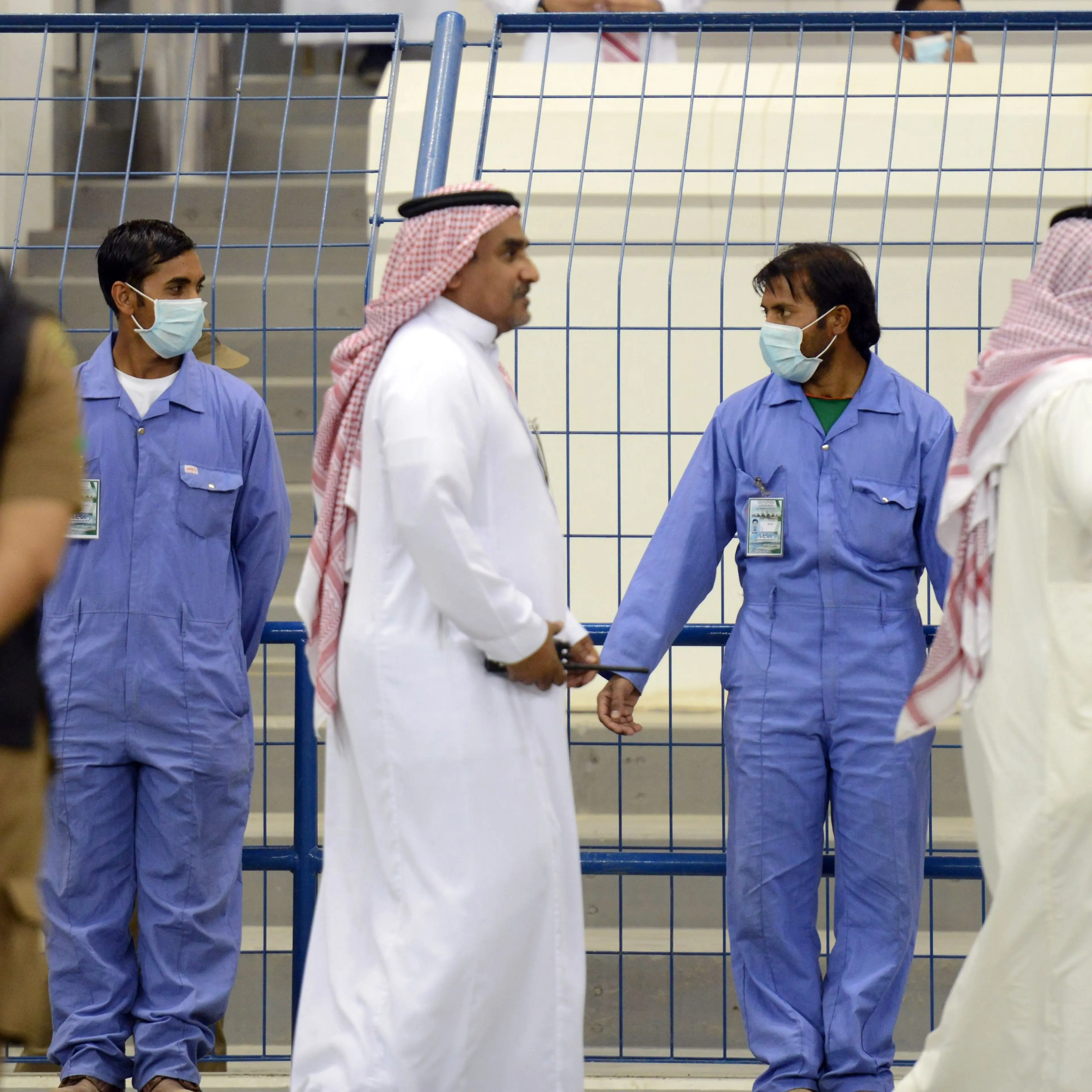 Asian workers wear mouth and nose masks while on duty during a football match at the King Fahad stadium, on April 22, 2014 in Riyadh.