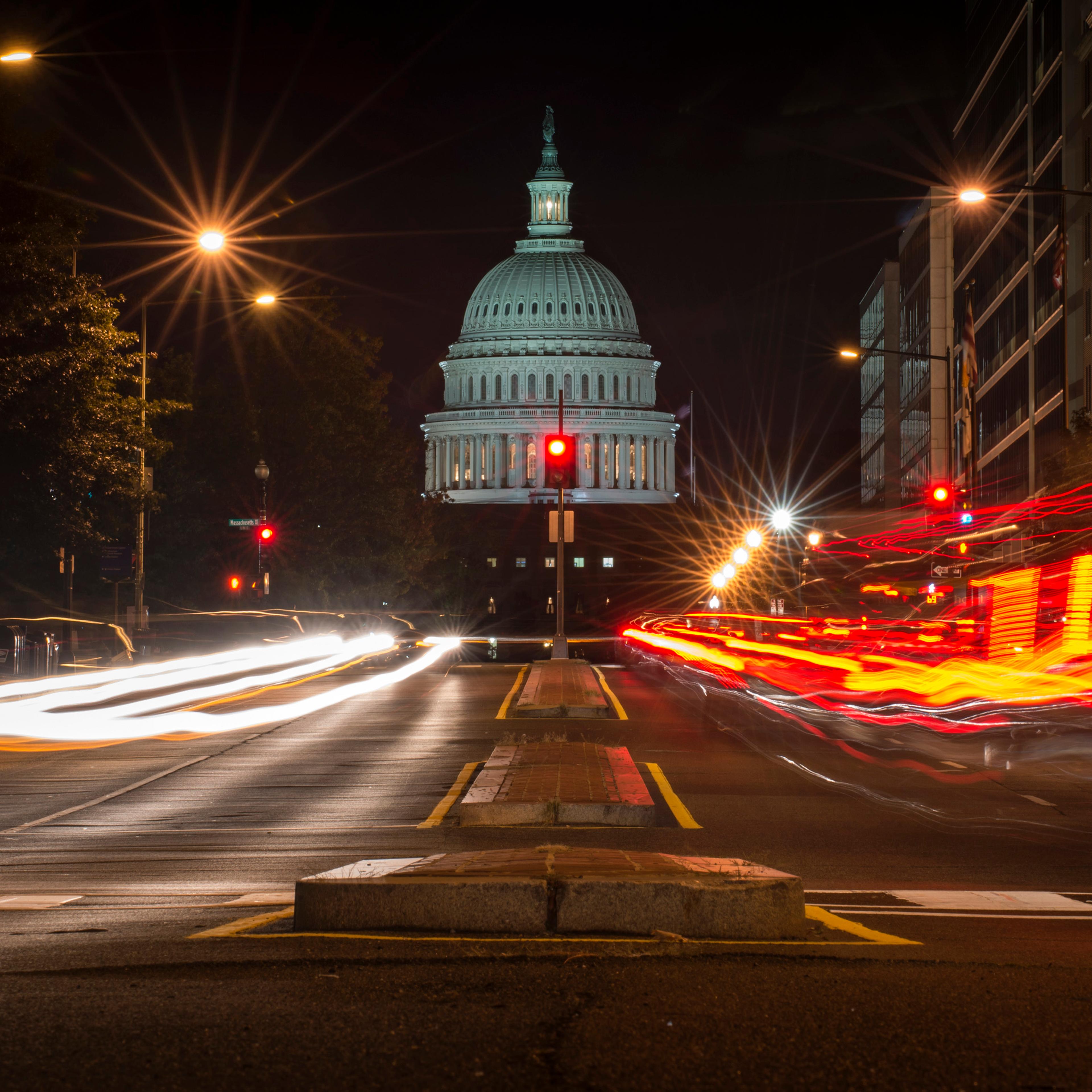 A red traffic light stands in front of the U.S. Capitol building in Washington