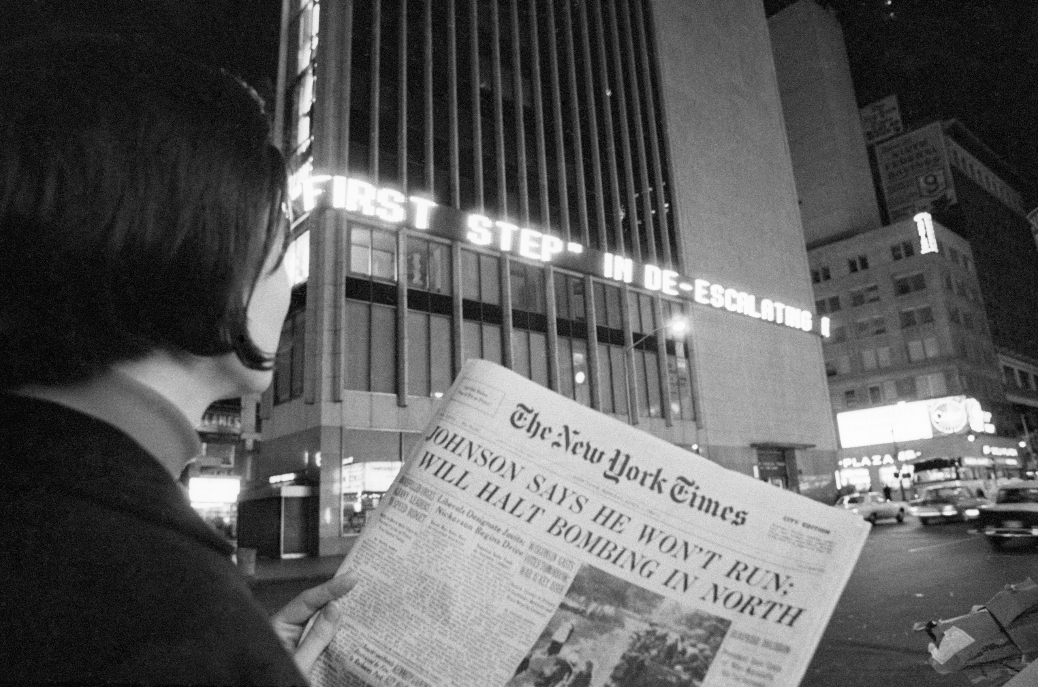 A woman reads the first page of the New York Times of Aril 1, 1968, when the headlines declared : "Johnson Says He Won't Run; Will Halt Bombing in North". This referred to President Johnson's refusal to accept or seek renomination.