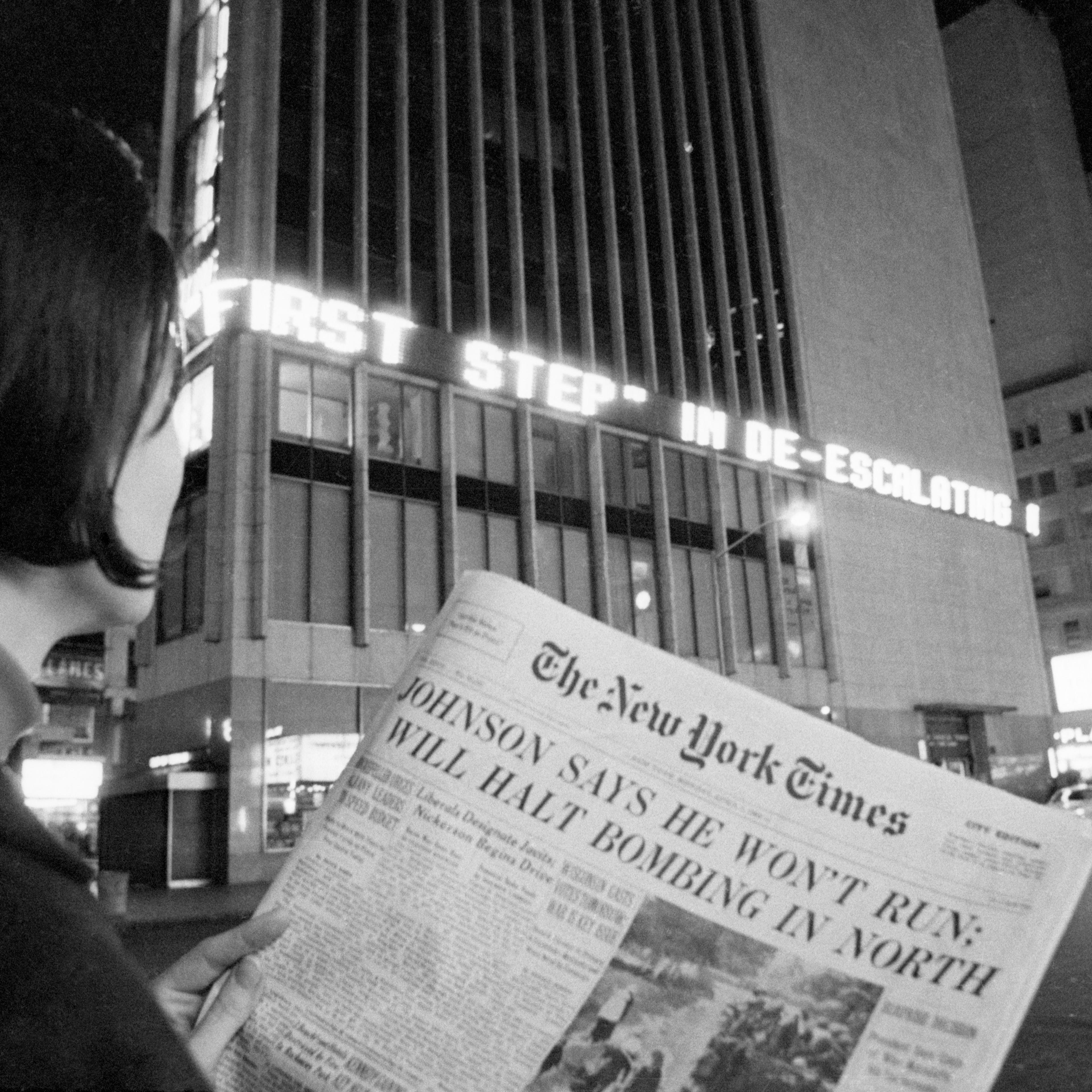 A woman reads the first page of the New York Times of Aril 1, 1968, when the headlines declared : "Johnson Says He Won't Run; Will Halt Bombing in North". This referred to President Johnson's refusal to accept or seek renomination.