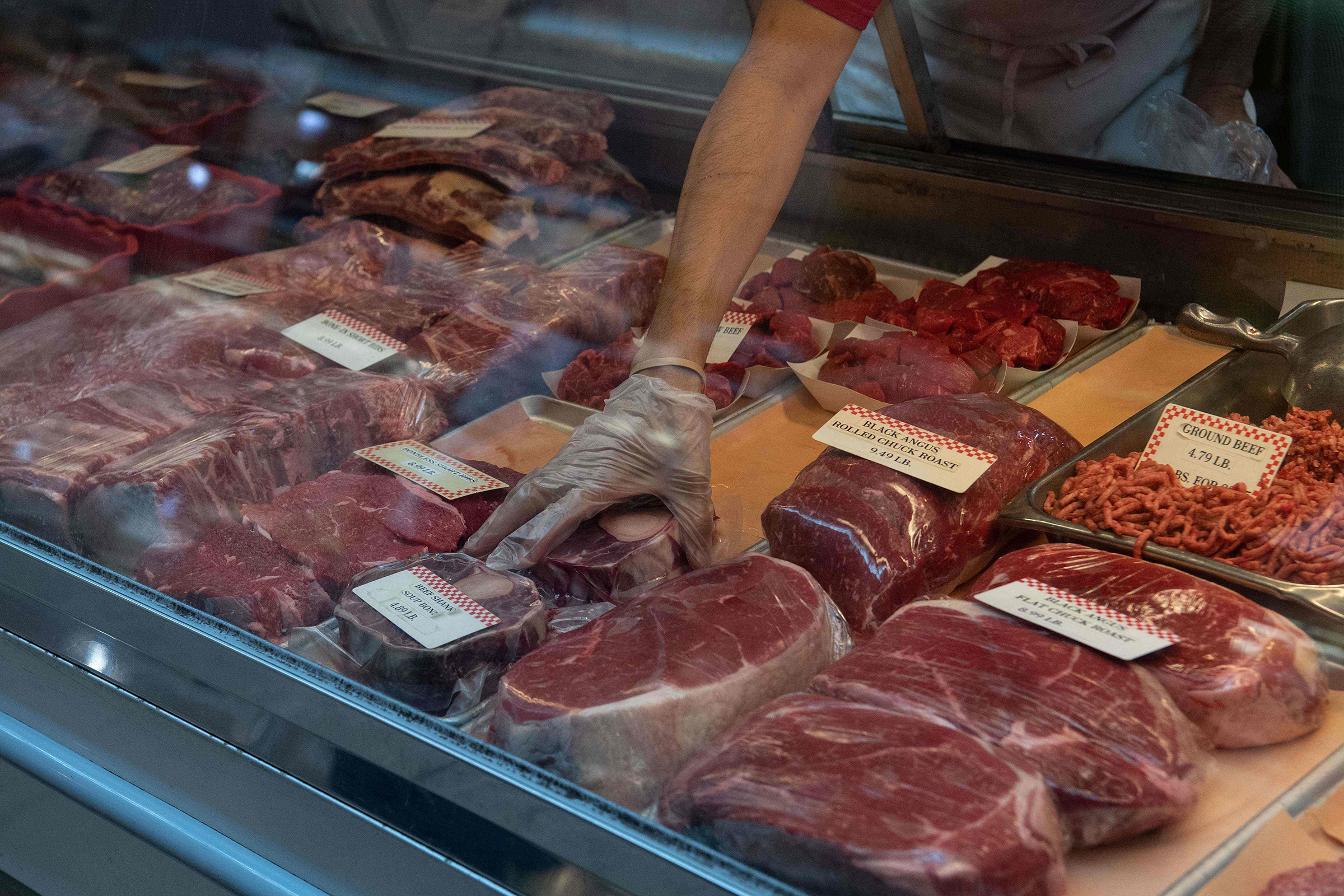 A butcher picks up a cut of beef at Eastern Market in Washington, D.C., on May 5