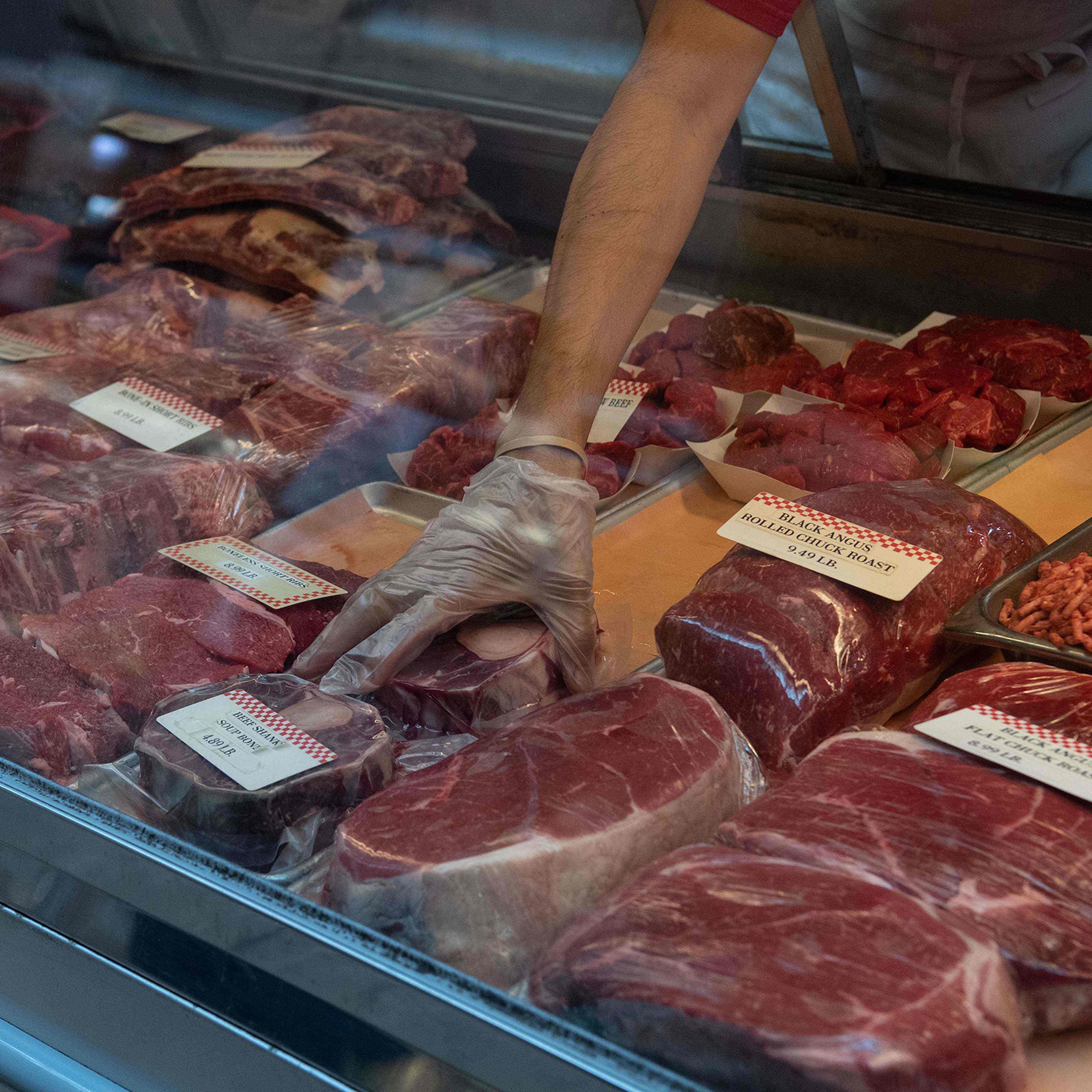 A butcher picks up a cut of beef at Eastern Market in Washington, D.C., on May 5