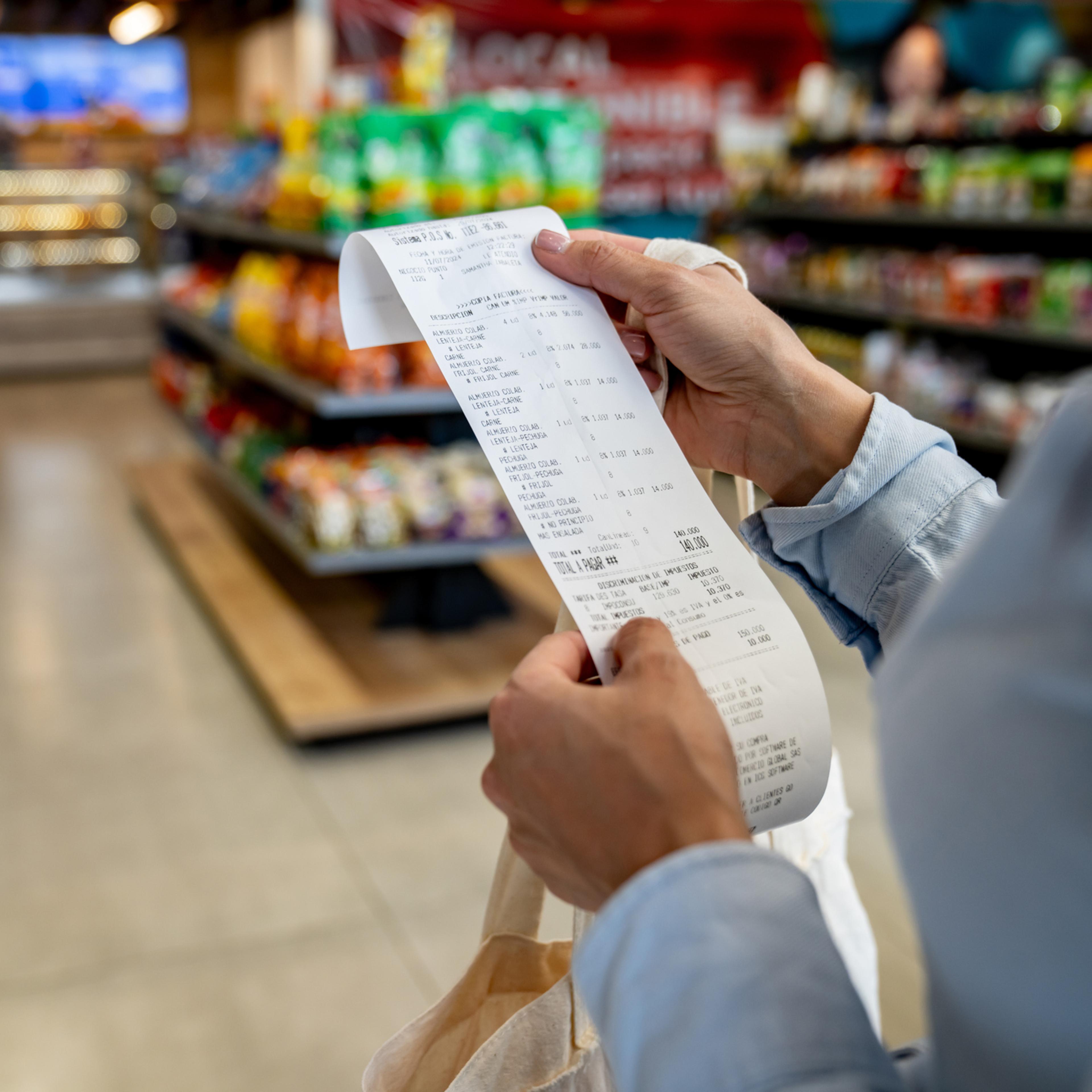 Woman shopping at a convenience store and checking her receipt