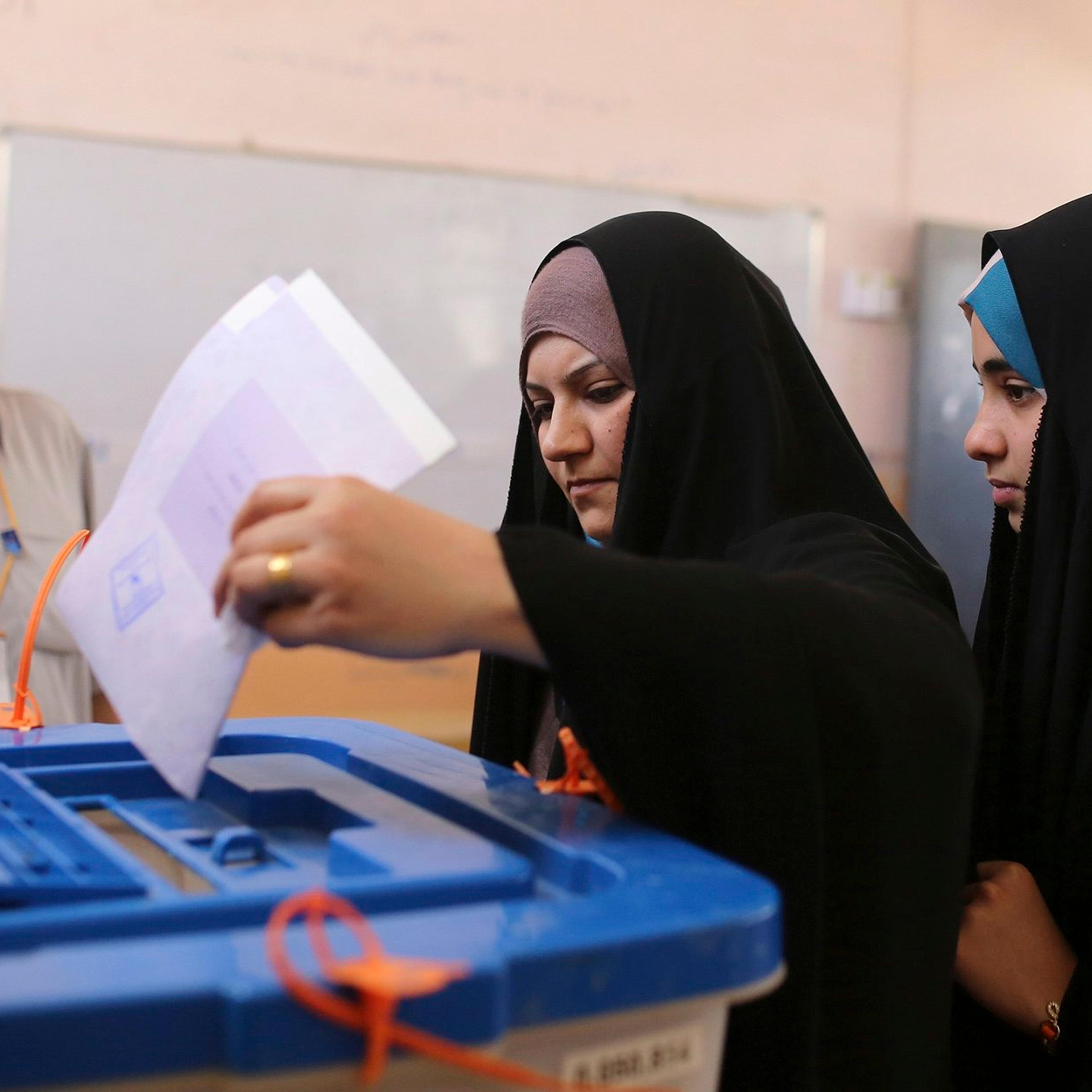 A resident casts her ballot at a polling station during Iraqi parliamentary election in Najaf