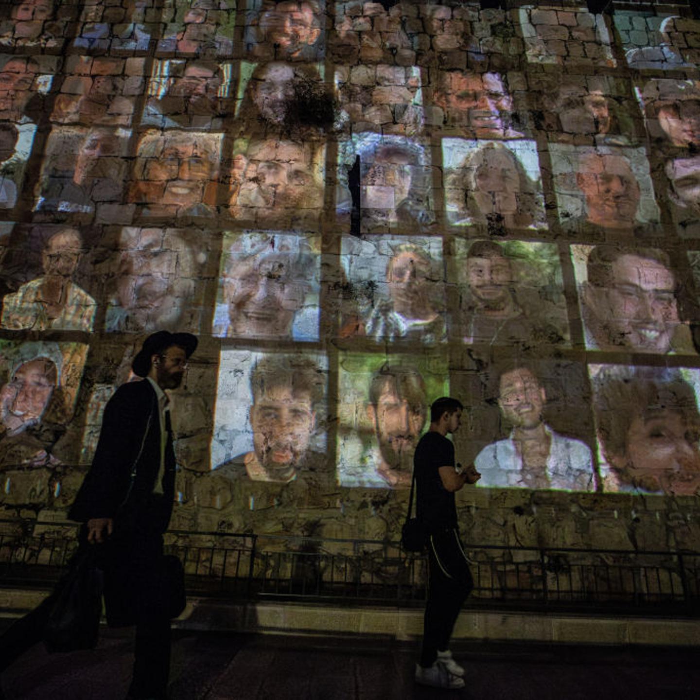 Photographs of Israelis taken hostage by Hamas are reflected on the walls of the Old City in Jerusalem