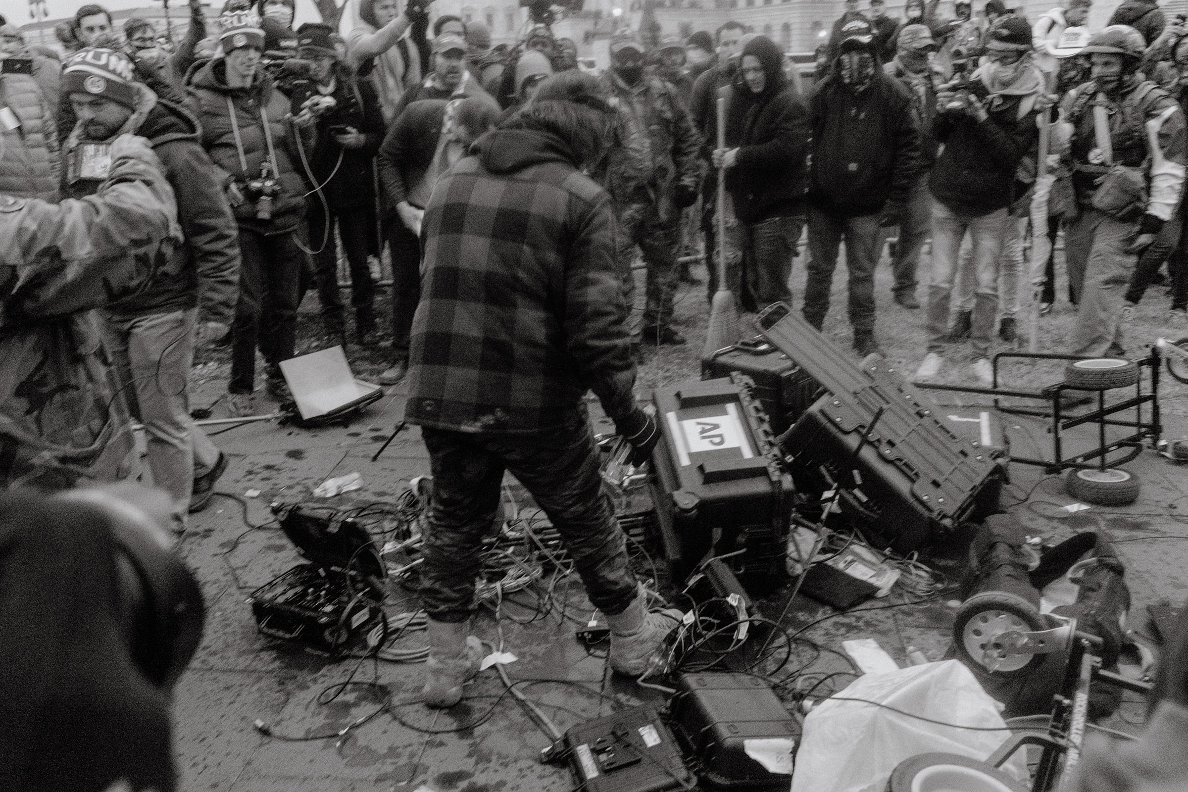 Pro-Trump rioters vandalize Associated Press journalist's equipment outside of the Capitol.