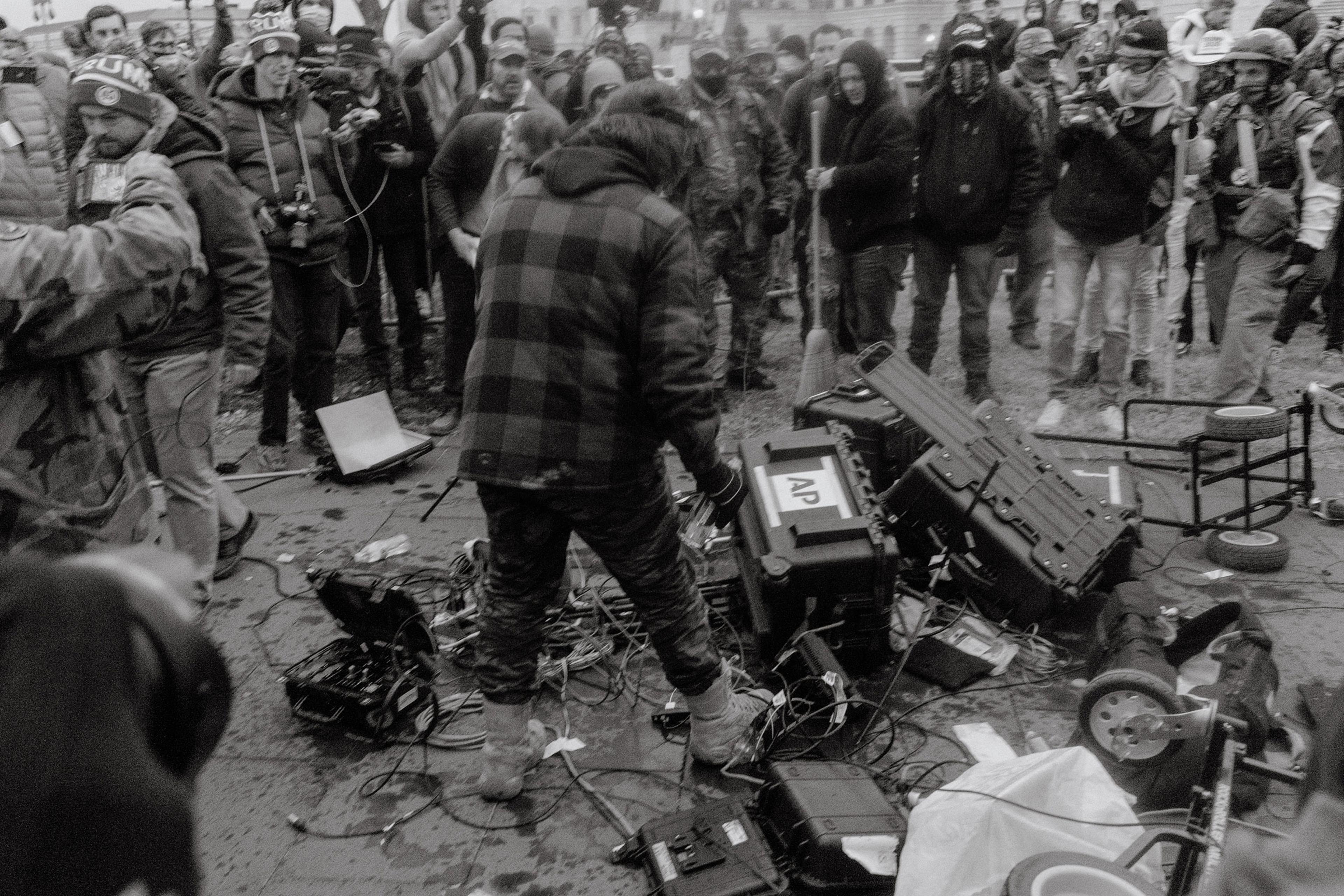 Pro-Trump rioters vandalize Associated Press journalist's equipment outside of the Capitol.