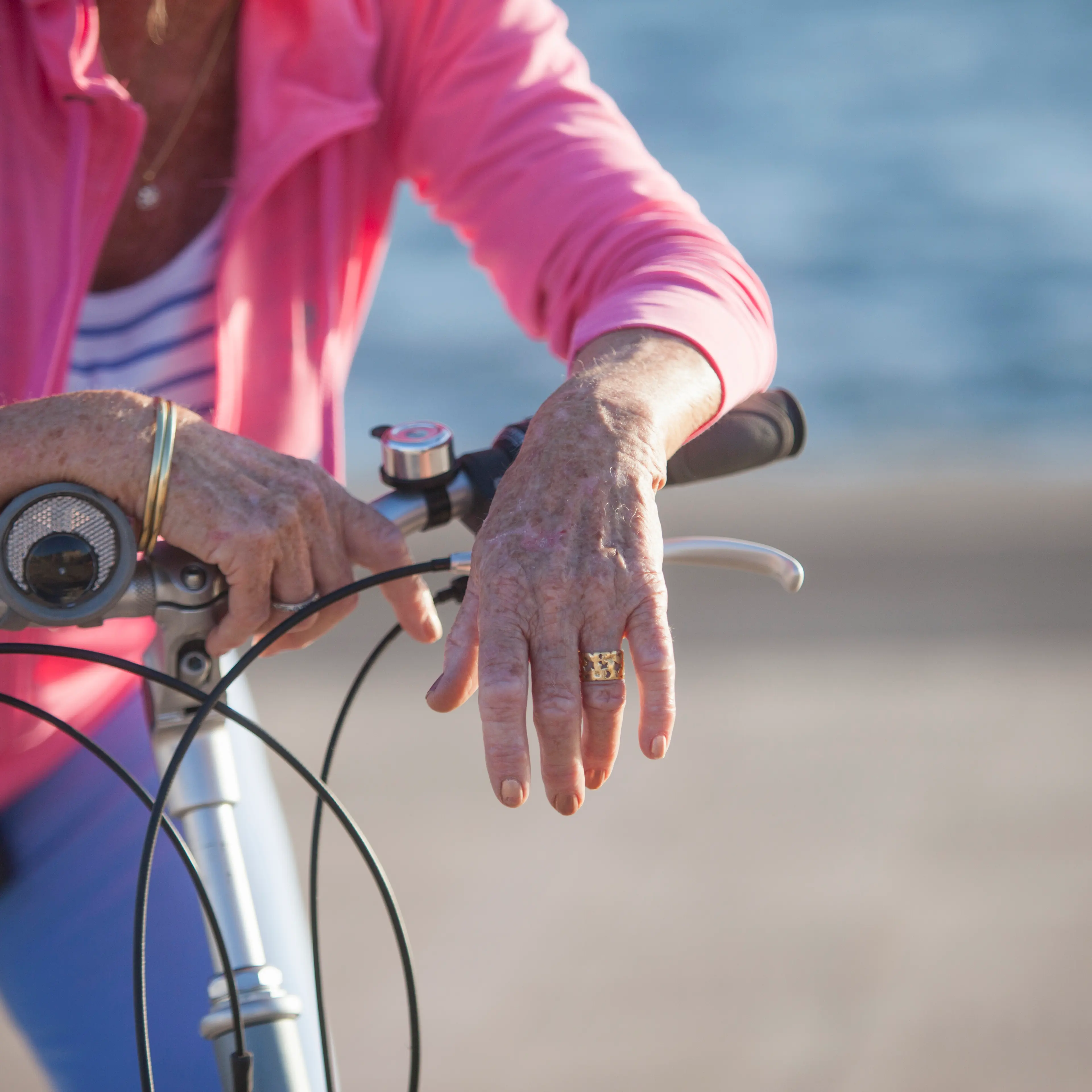 Senior woman on bicycle by beach
