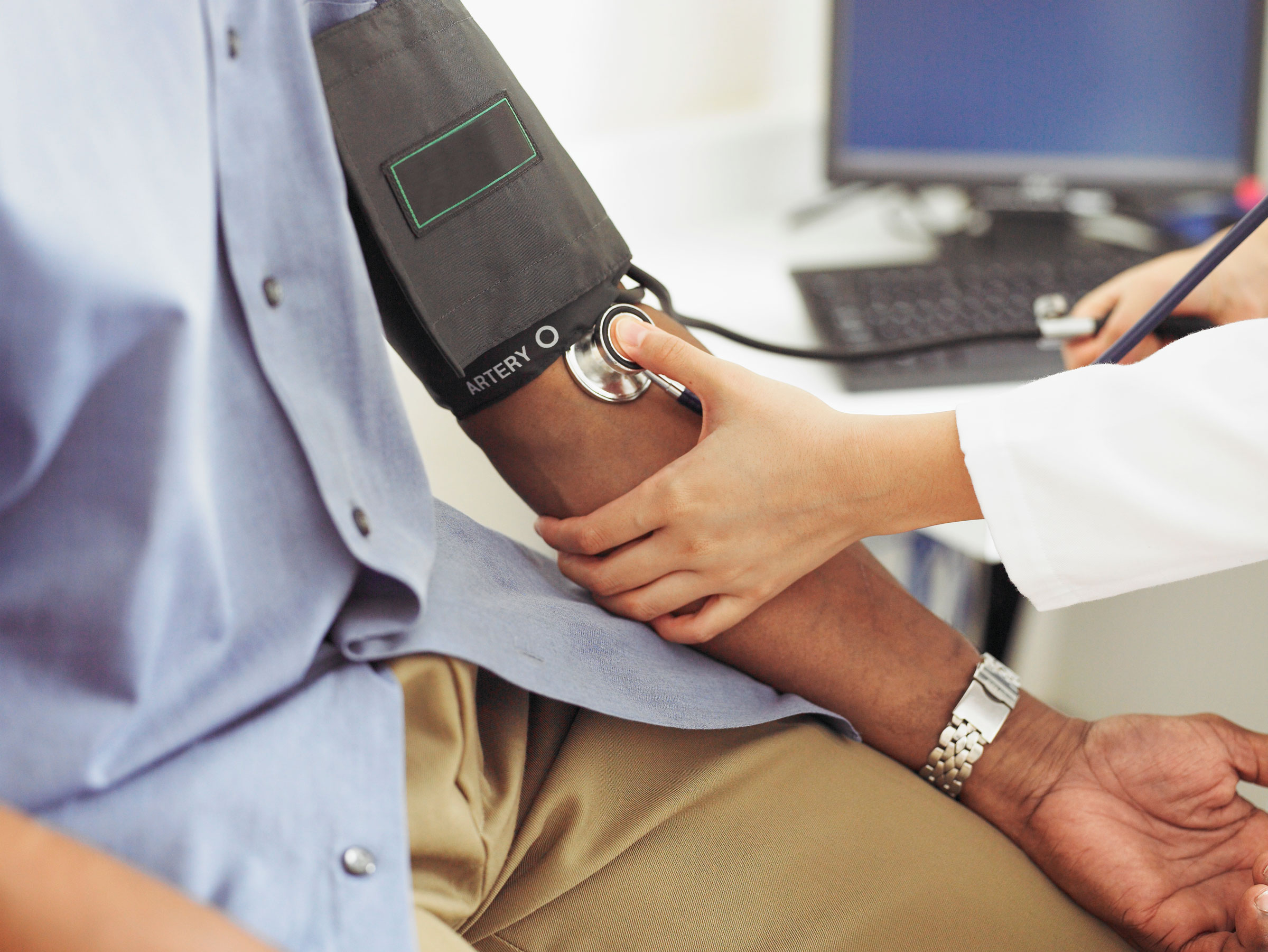 doctor taking patient's blood pressure