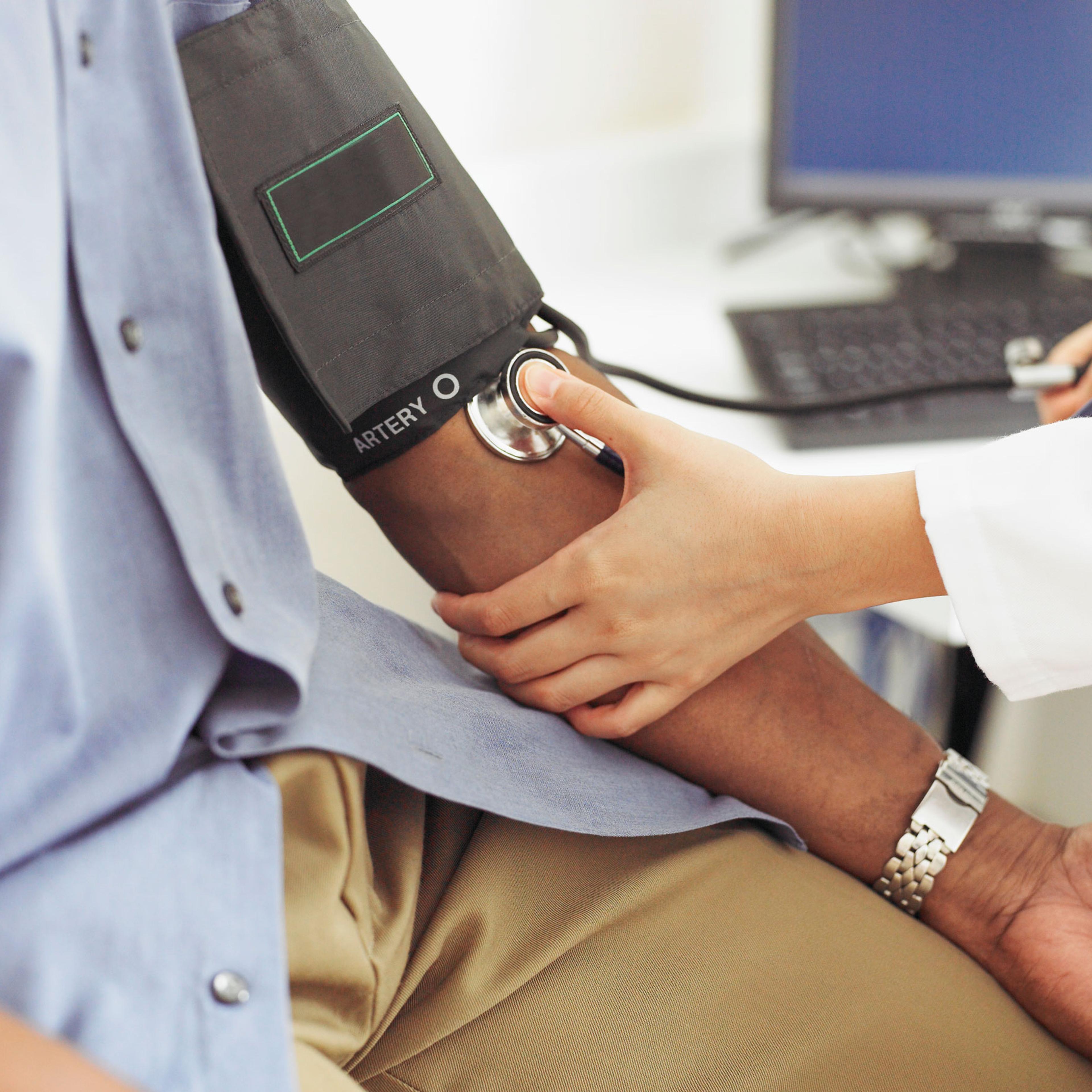 doctor taking patient's blood pressure